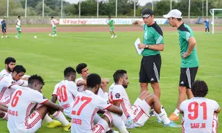 Alexandre (de boné) durante um treino do Al Sharjah, com o tradutor ao lado