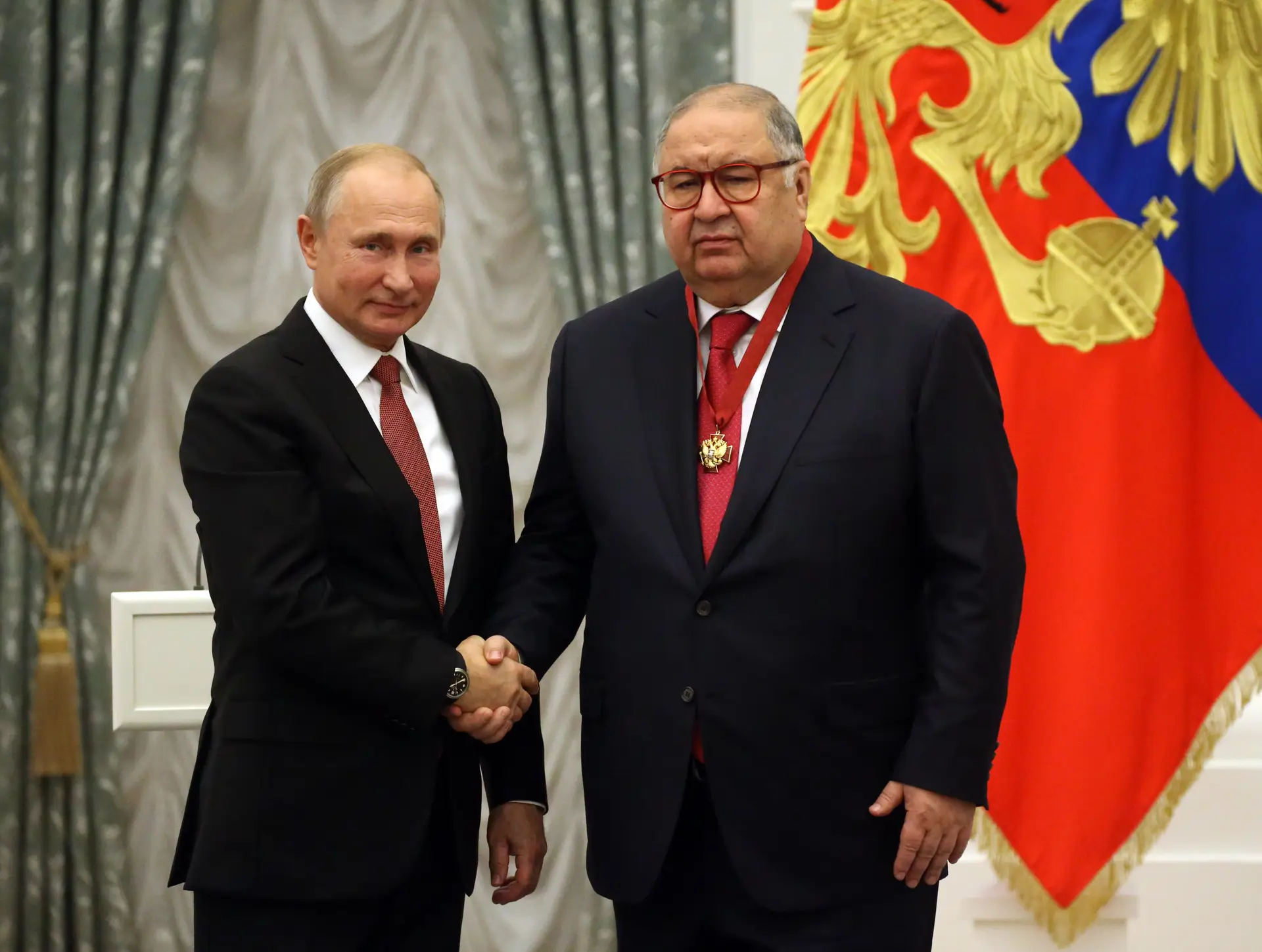 Alisher Usmanov cumprimenta Vladimir Putin depois de receber uma condecoração das mãos do presidente russo