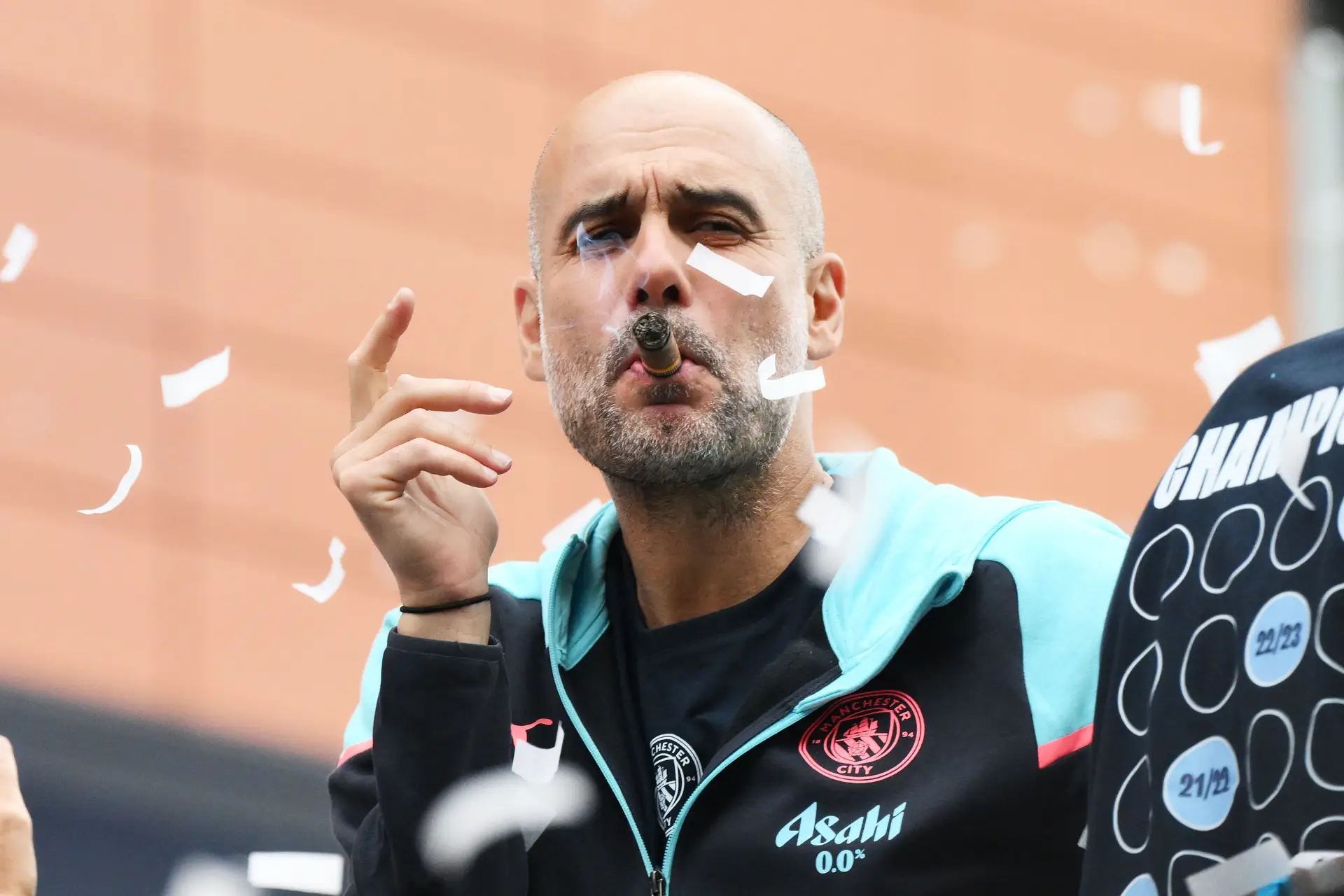 Com um charuto, a celebrar a conquista da última Premier League, quando fez do Manchester City a primeira equipa a ser tetracampeã em Inglaterra.