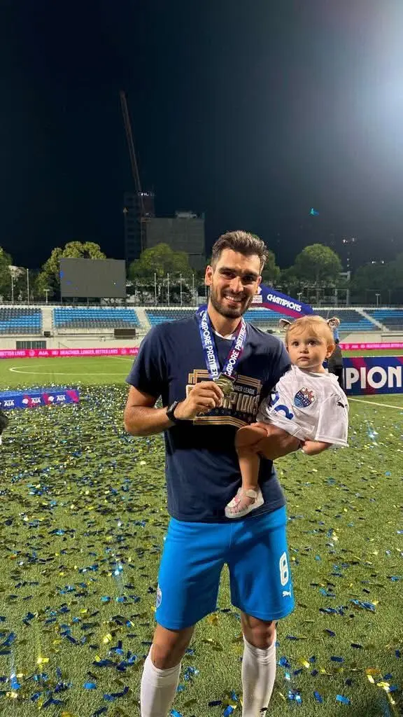 Com a medalha de campeão de Singapura e a filha Carolina ao colo