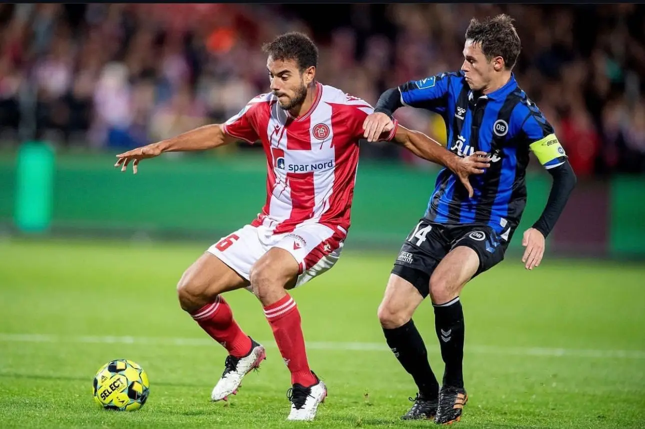 O médio (à esquerda) em ação pelo Aalborg BK 