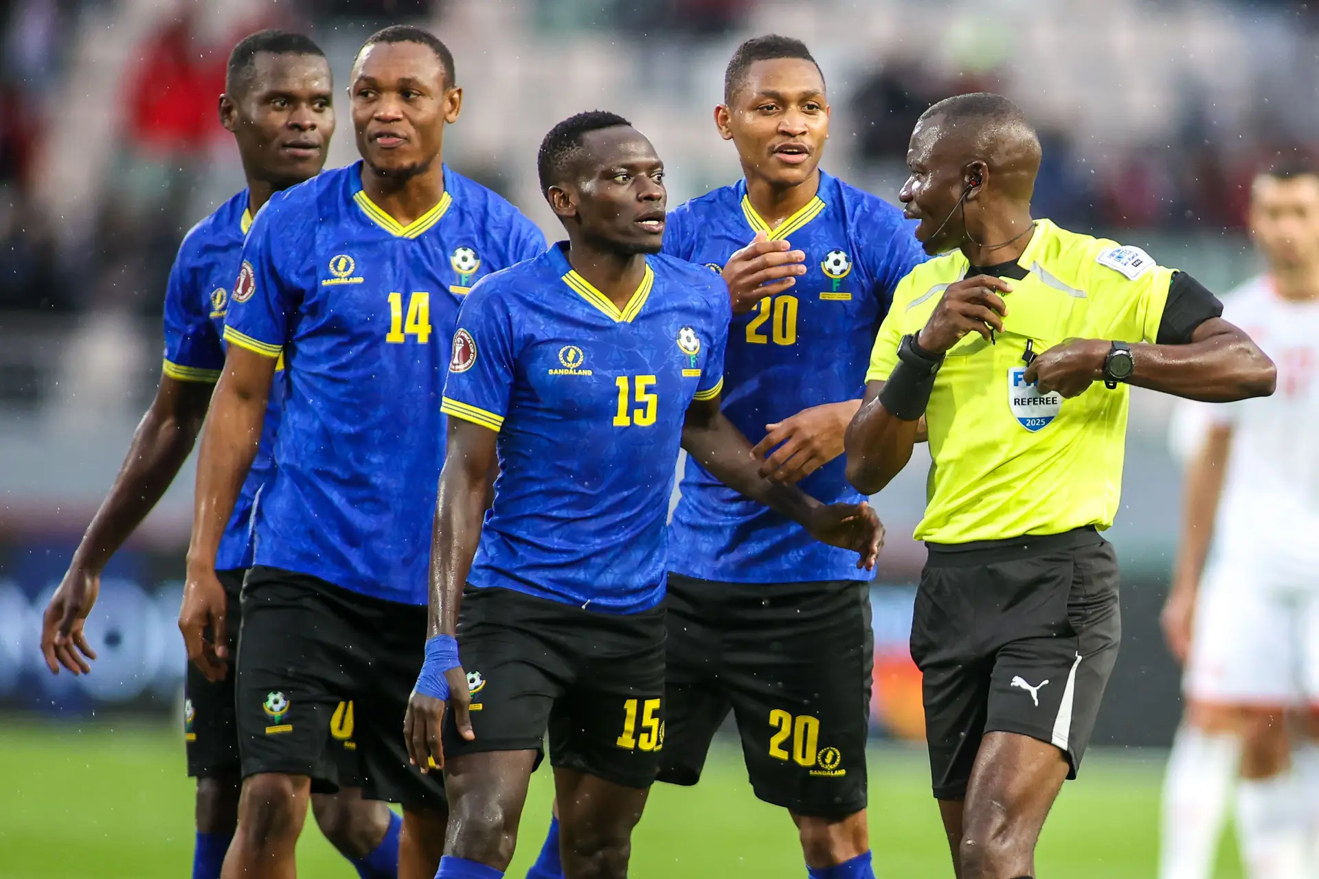 Jogadores da Tanzânia rodeiam o árbitro no encontro decisivo da fase de grupos contra a Tunísia