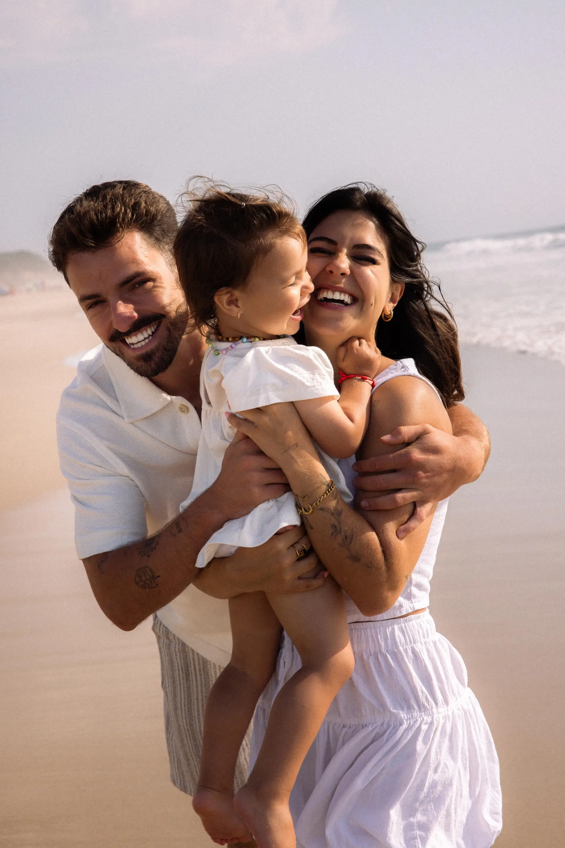 O médio com a namorada e a filha na praia