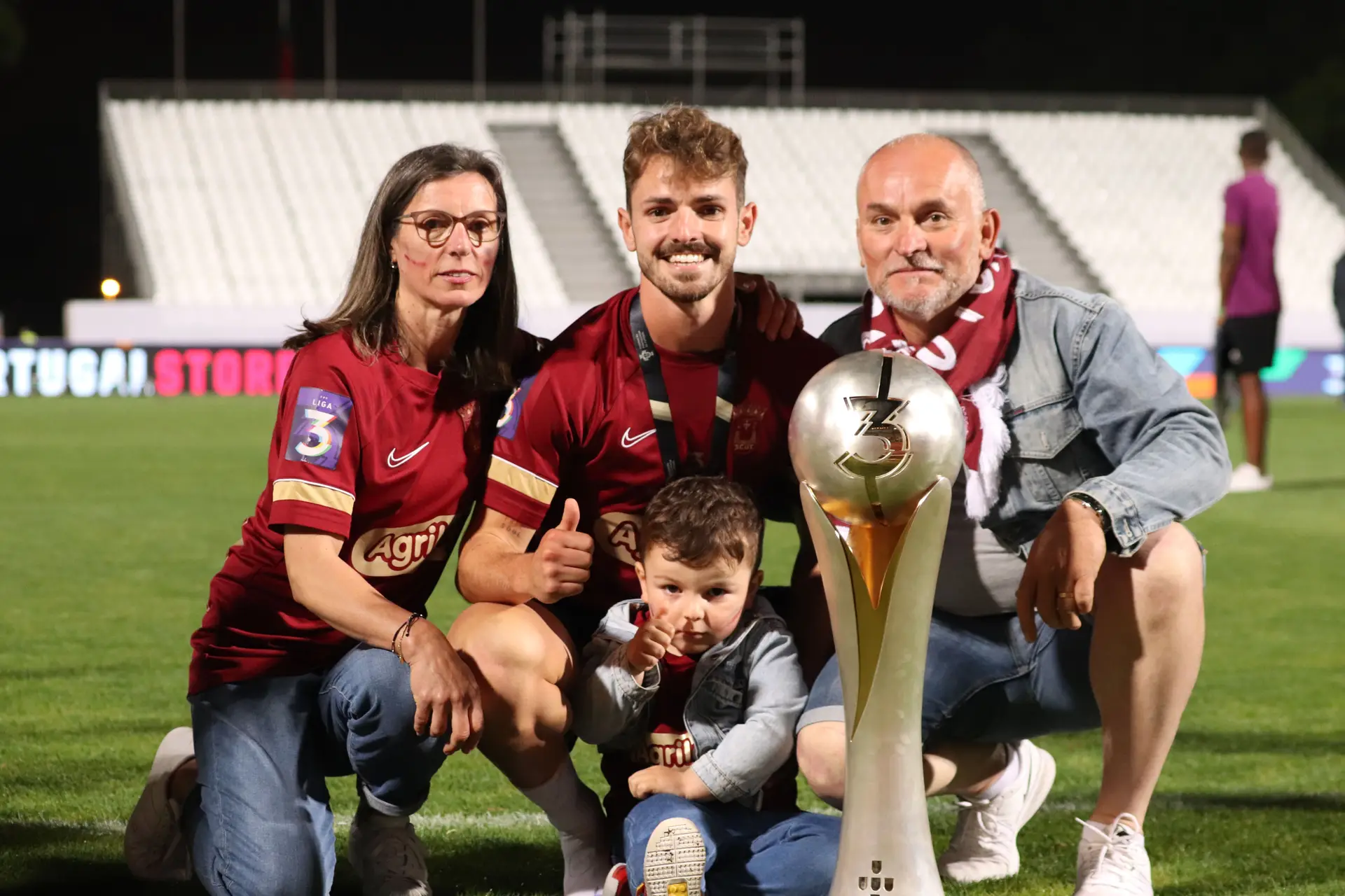 João com os pais, o sobrinho e a Taça de Campeão da Liga 3