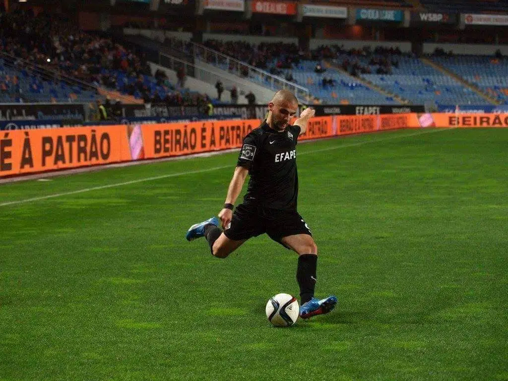 O médio prepara-se para chutar a bola, na Académica de Coimbra