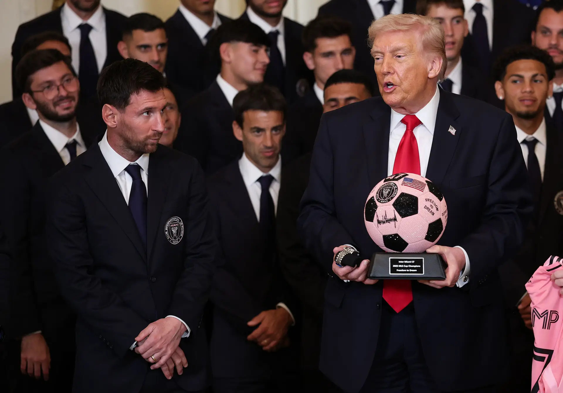 Messi a olhar para Trump, que segura num dos presentes que o Inter Miami ofereceu ao presidente
