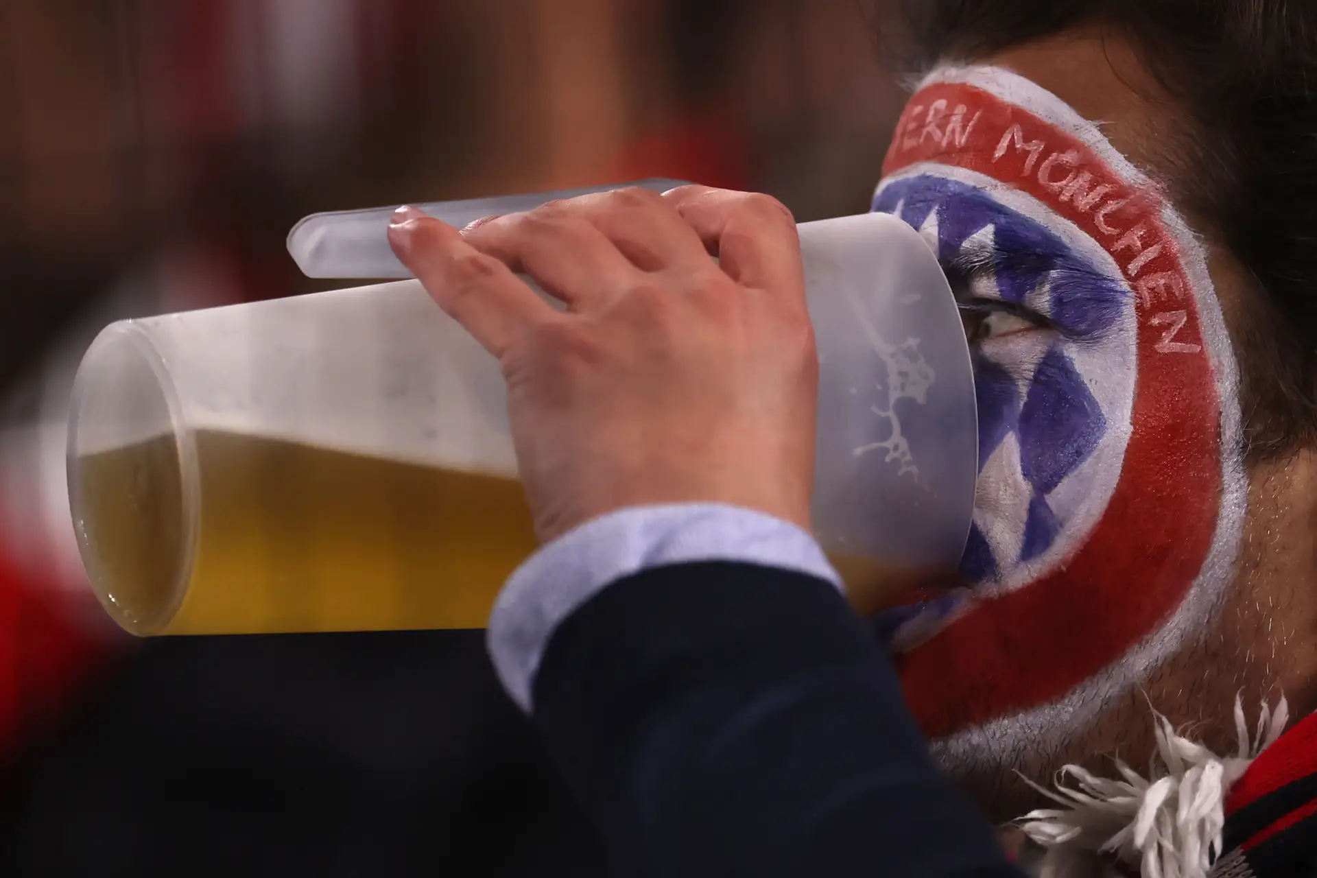 Um adepto do Bayern de Munique a beber um generoso copo de cerveja na Allianz Arena. A Alemanha permite o consumo de bebidas alcoólicas dentro dos estádios de futebol
