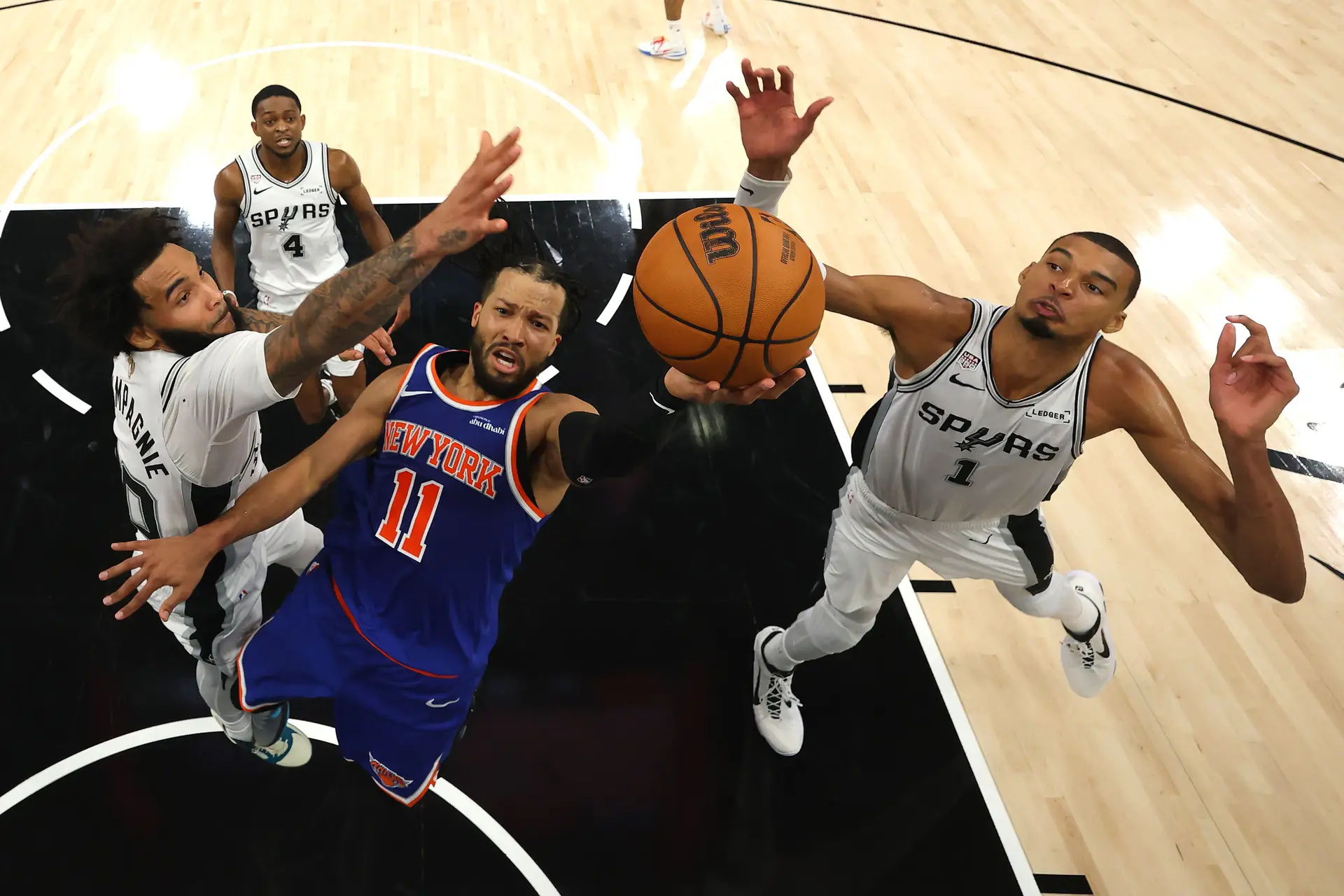 Jalen Brunson, dos New York Knicks, a atacar o cesto durante o Jogo 2 das finais da NBA, rodeado por jogadores dos San Antonio Spurs
