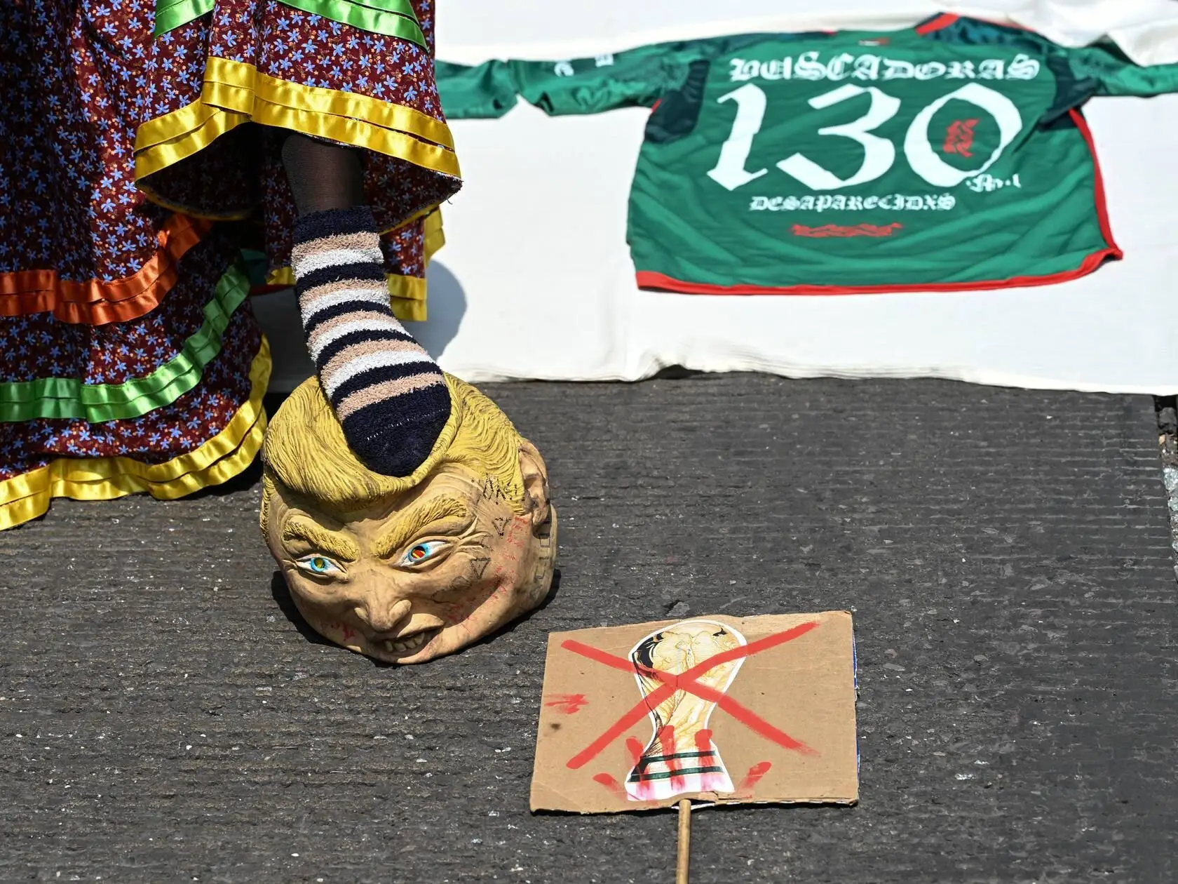 Ativistas de um coletivo feminista protestam contra o Mundial 2026 da FIFA jogam futebol com uma bola coberta por uma máscara com a imagem do Presidente dos EUA, Donald Trump, na Cidade do México, a 16 de maio de 2026