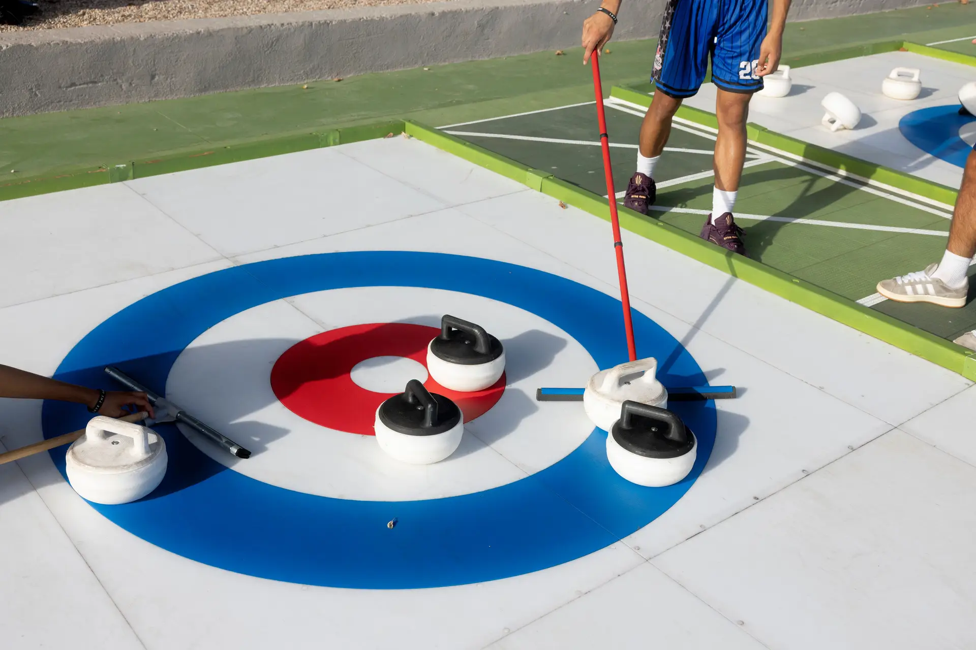 Italianos a jogarem curling no rinque montado no centro de Roma