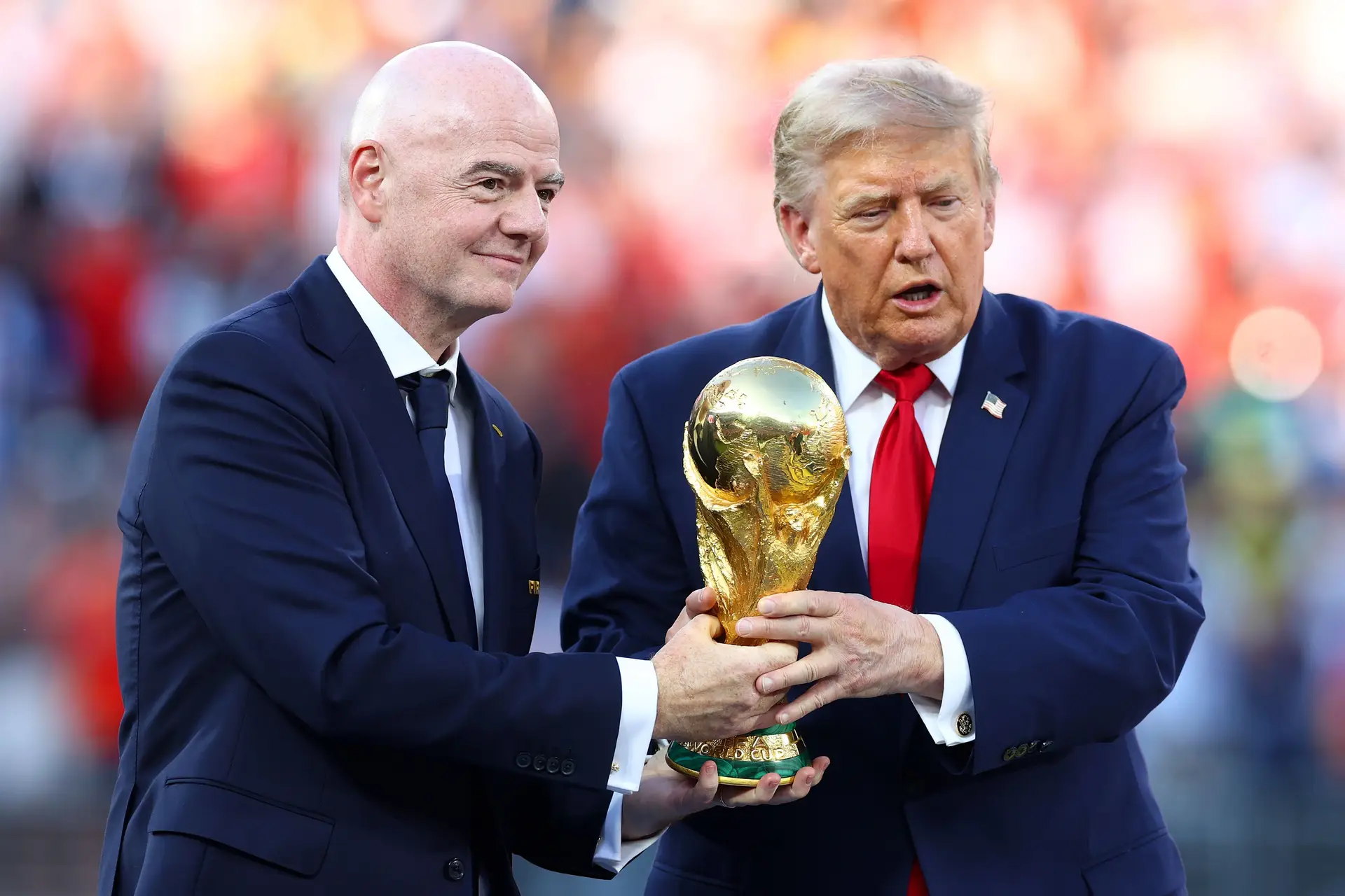 Gianni Infantino e Donald Trump agarrados ao troféu do Mundial antes de o entregarem aos jogadores de Espanha, vencedora da final da edição de 2026 do torneio