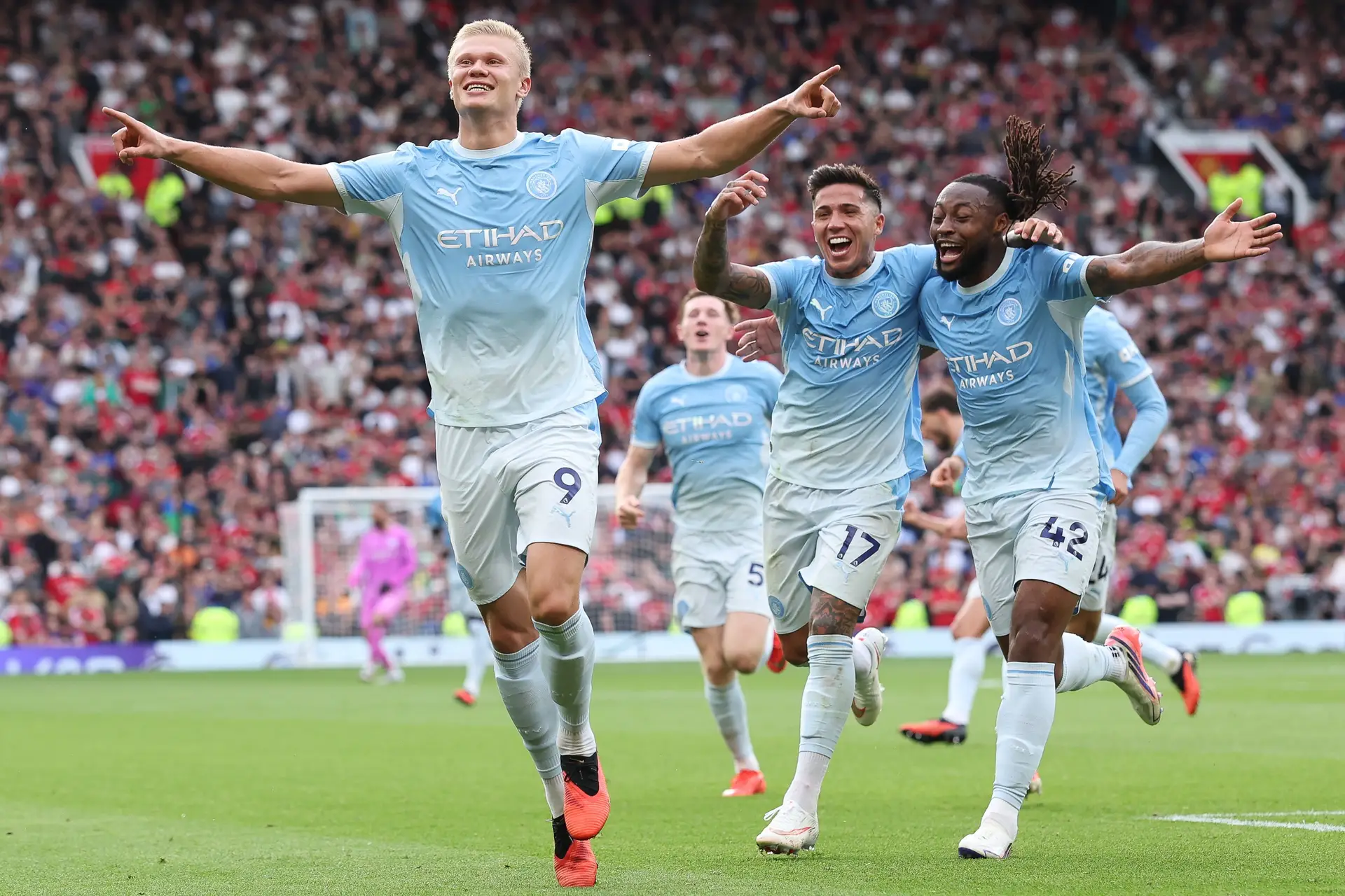 Erling Haaland, com outros jogadores do Manchester City atrás, a festejar um golo que marcou em casa do United no dérbi da cidade, a contar para a Premier League