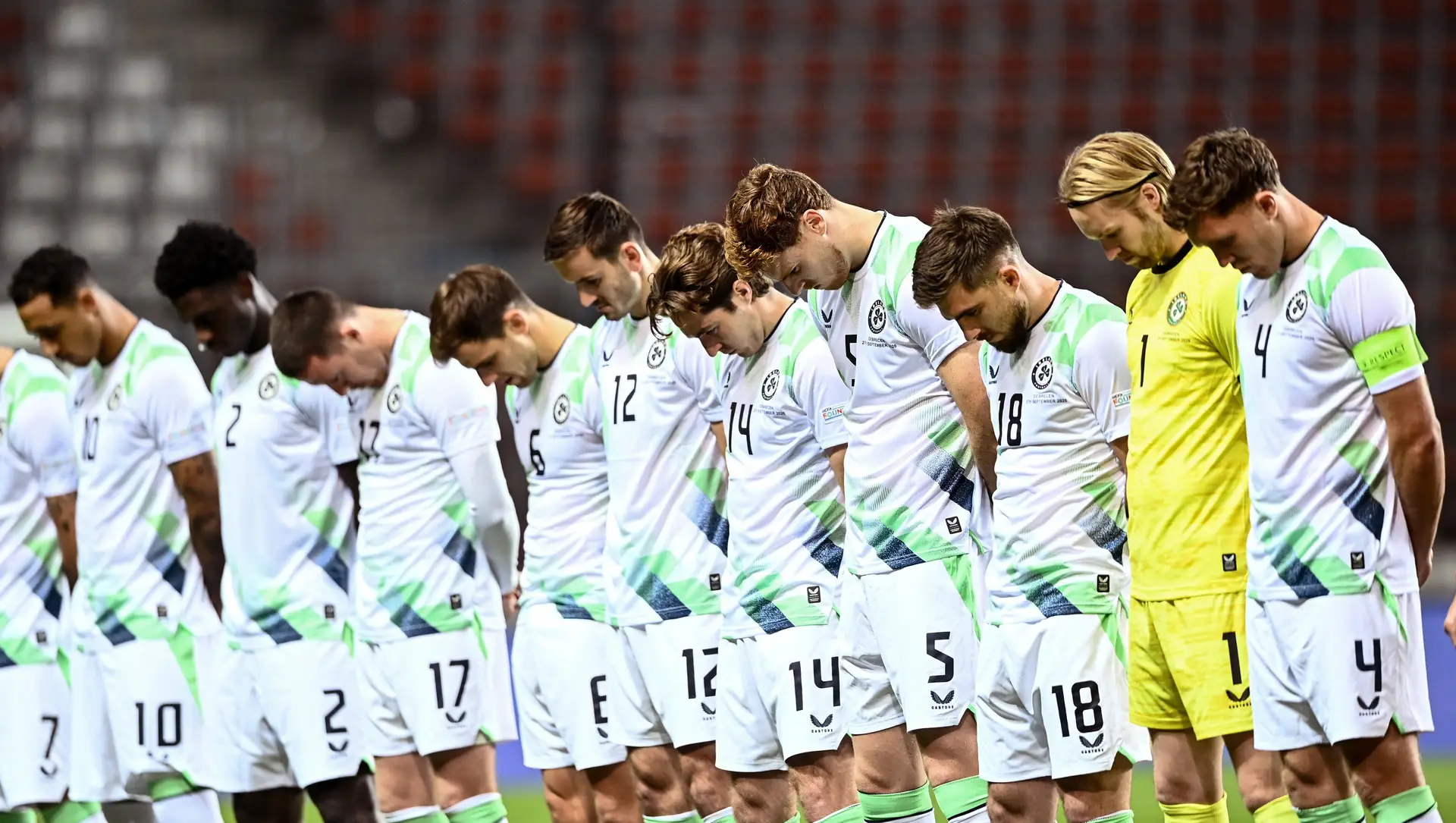 Os jogadores da seleção irlandesa, todos de cabeça baixa, no momento em que tocou no estádio o hino nacional de Israel