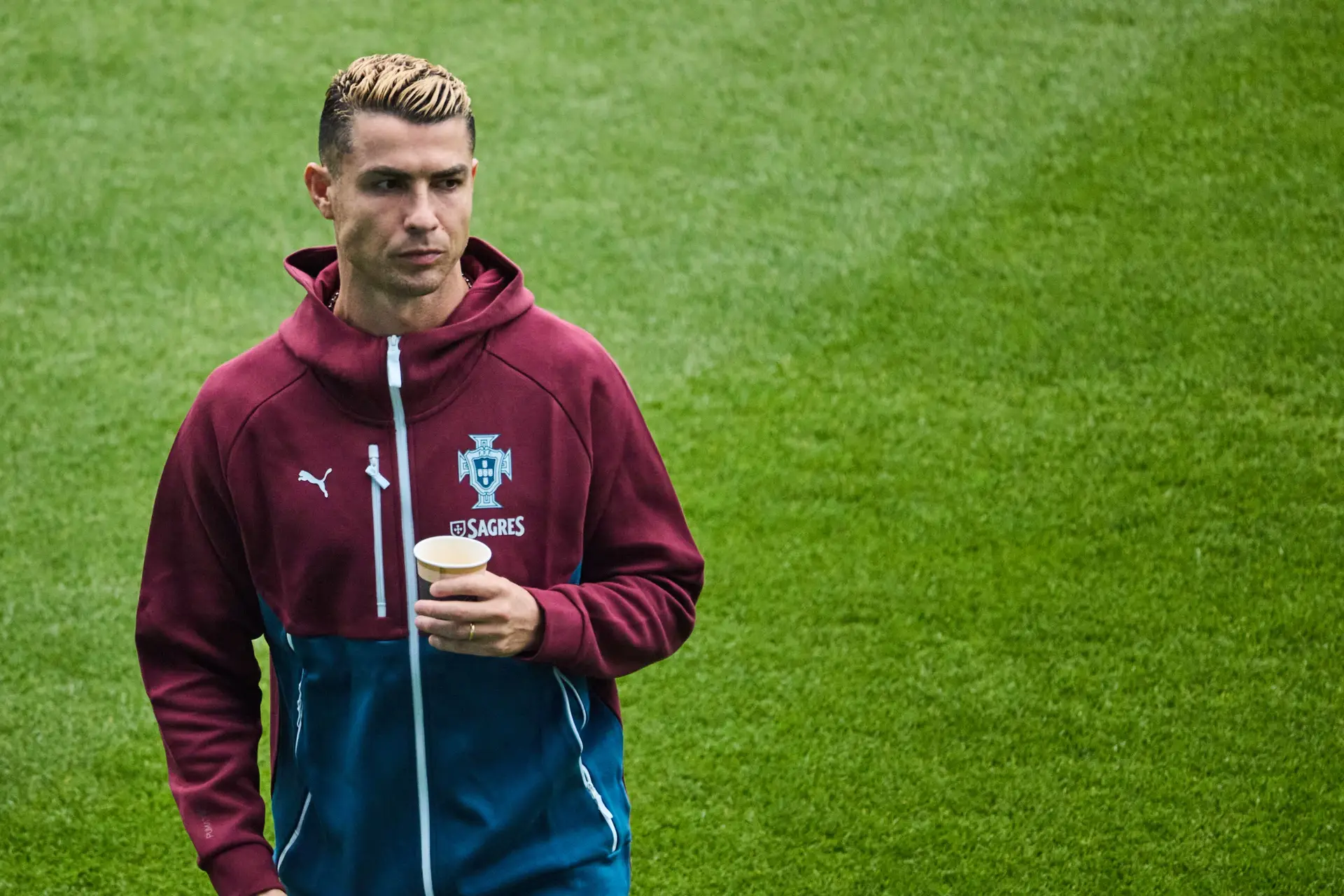 Cristiano Ronaldo a segurar um copo no relvado do estádio de Malmö, onde compareceu mas não chegou a treinar com a seleção nacional