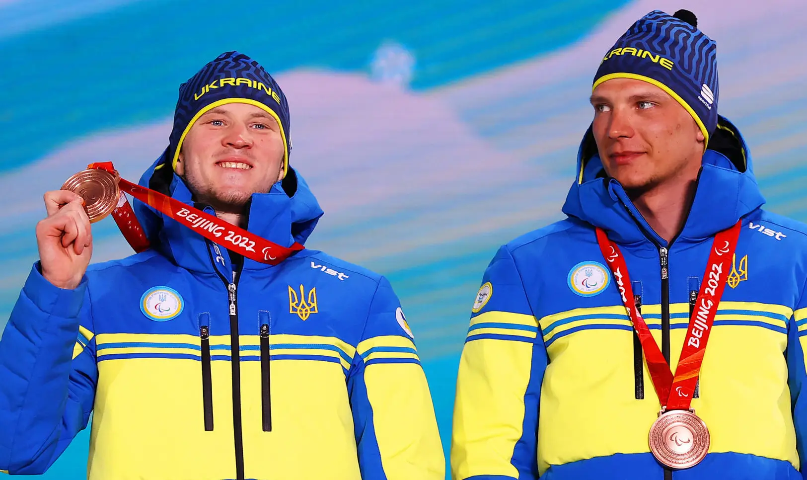 ZHANGJIAKOU, CHINA – MARCH 08: Bronze medallist Dmytro Suiarko of Team Ukraine and guide Oleksandr Nikonovych celebrate during the Men’s Para Biathlon Middle Distance Vision Impaired medal ceremony at the Zhangjiakou Medals Plaza on day four of the Beijing 2022 Winter Paralympics on March 08, 2022 in Zhangjiakou, China. (Photo by Michael Steele/Getty Images)