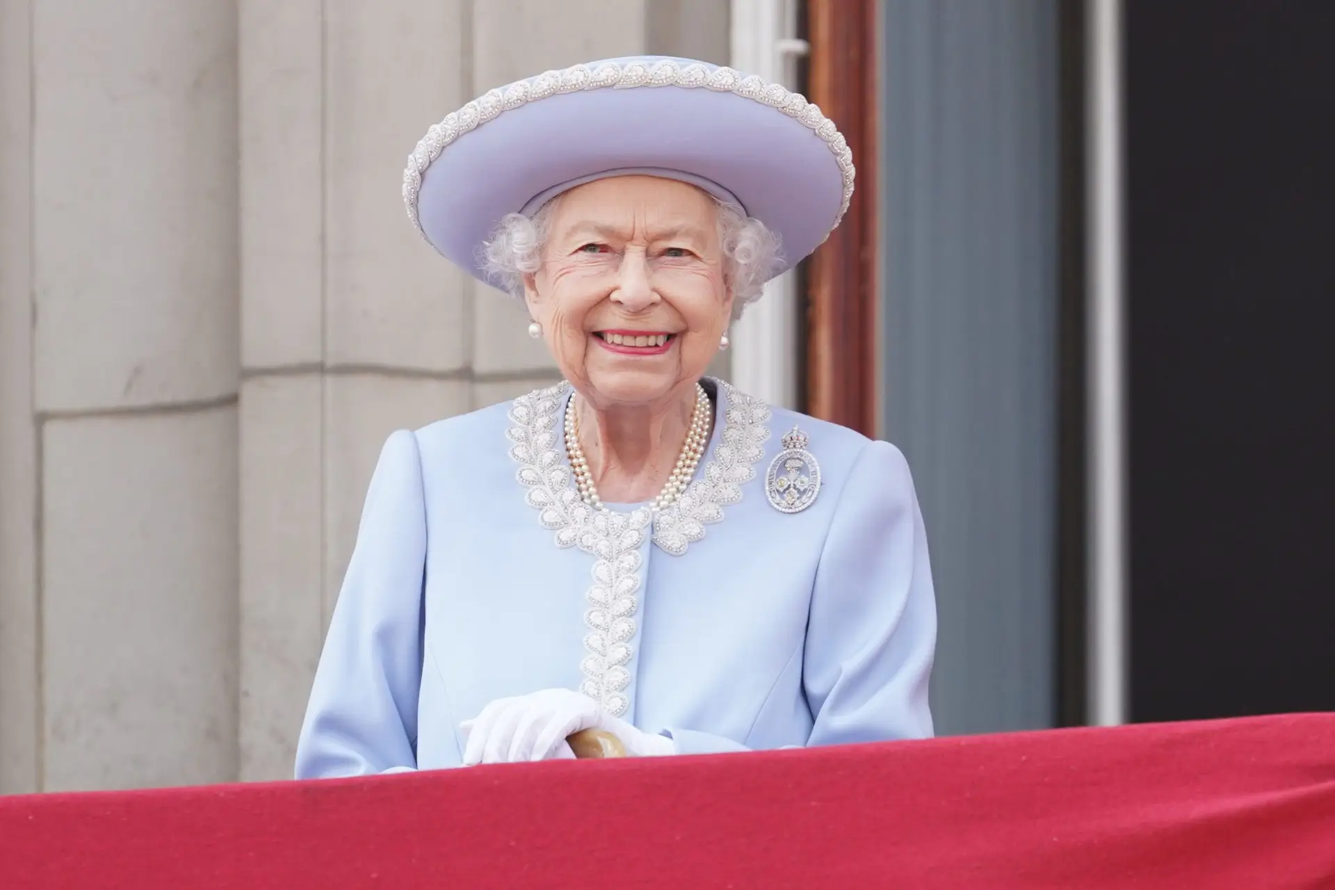 LONDON, ENGLAND – JUNE 02: Queen Elizabeth II watches from the balcony of Buckingham Palace during the Trooping the Colour parade the Trooping the Colour parade on June 2, 2022 in London, England. Trooping The Colour, also known as The Queen’s Birthday Parade, is a military ceremony performed by regiments of the British Army that has taken place since the mid-17th century. It marks the official birthday of the British Sovereign. This year, from June 2 to June 5, 2022, there is the added celebration of the Platinum Jubilee of Elizabeth II in the UK and Commonwealth to mark the 70th anniversary of her accession to the throne on 6 February 1952. (Photo by Jonathan Brady – WPA Pool/Getty Images)