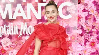 Miley Cyrus arrisca em vestido vermelho e transparente