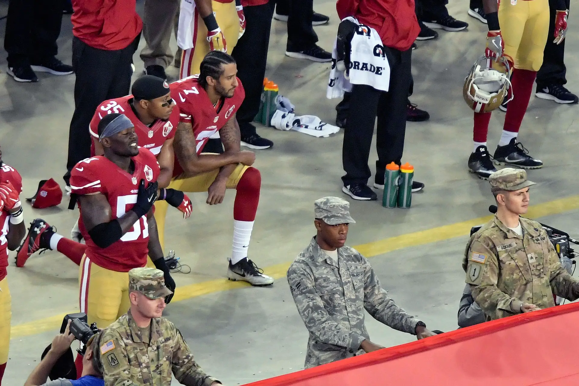 Colin Kaepernick e Eric Reid dos San Francisco 49ers ajoelham-se durante o hino nacional, antes de um jogo da NFL contra os Los Angeles Rams, Santa Clara, Califórnia