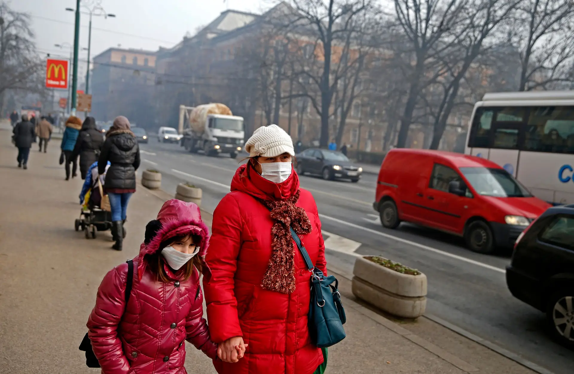 Mãe e filha protegem-se do "smog" em Sarajevo, na Bósnia e Herzegovina.