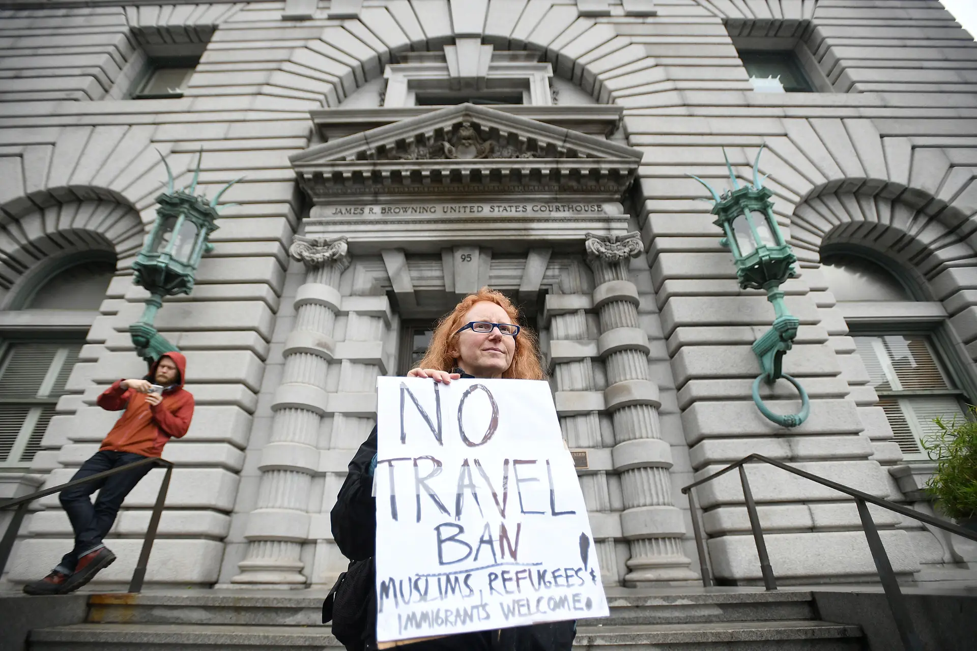 Protestos contra o decreto de Trump à porta do tribunal.