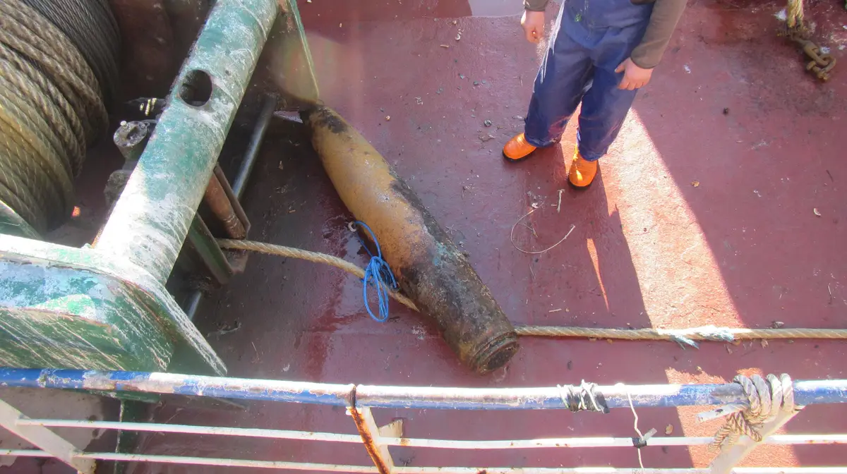 A bomba apanhada nas redes no convés do arrastão.