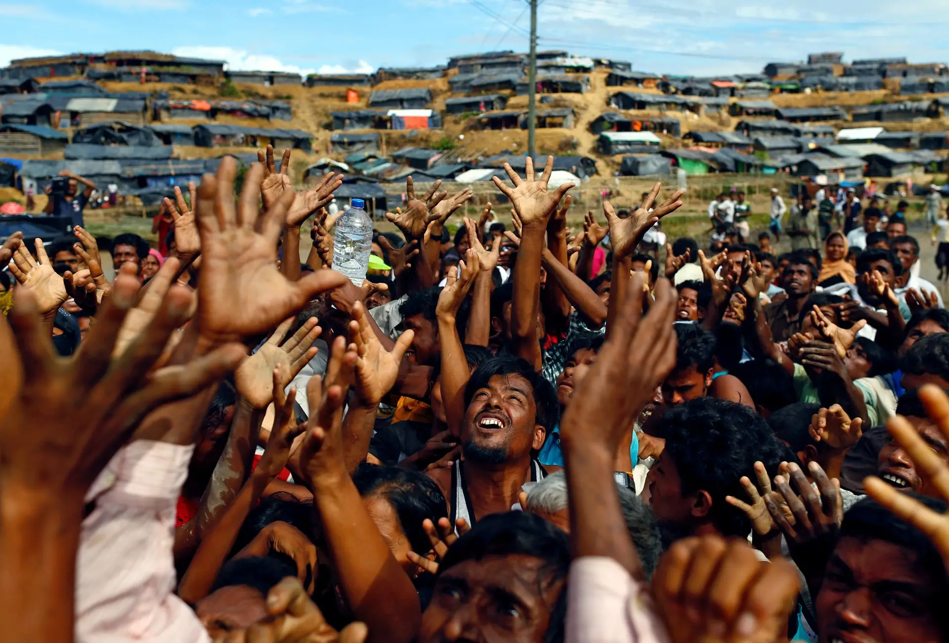 O desespero dos refugiados rohingya, de mão estendido para receber qualquer ajuda das organizações locais, no campo de refugiados improvisados Balukhali em Cox's Bazar, no Bangladesh. Fotografia tirada a 14 de setembro de 2017.