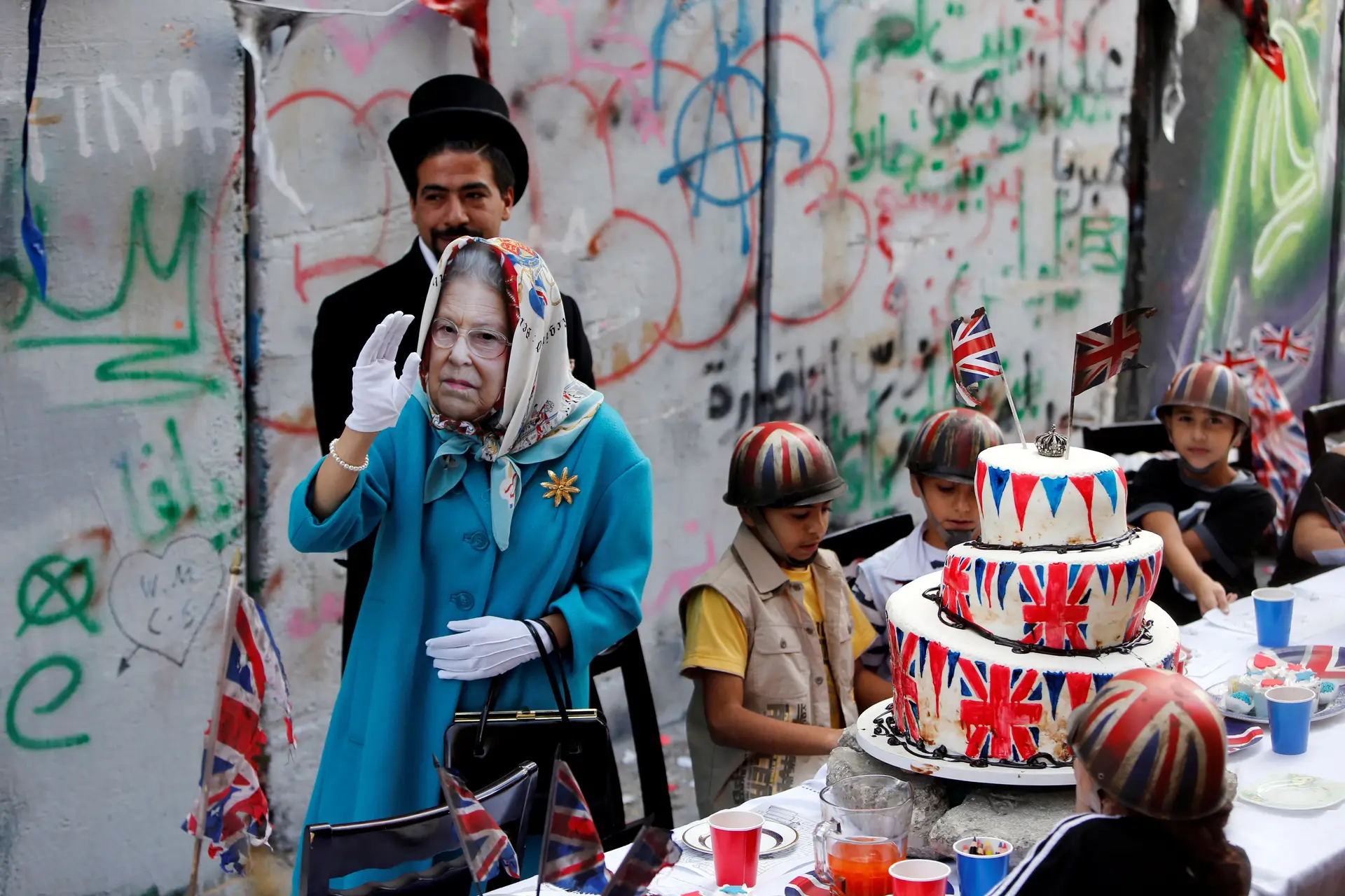 Crianças palestinianas foram recebidas por uma atriz disfarçada de rainha Isabel II de Inglaterra