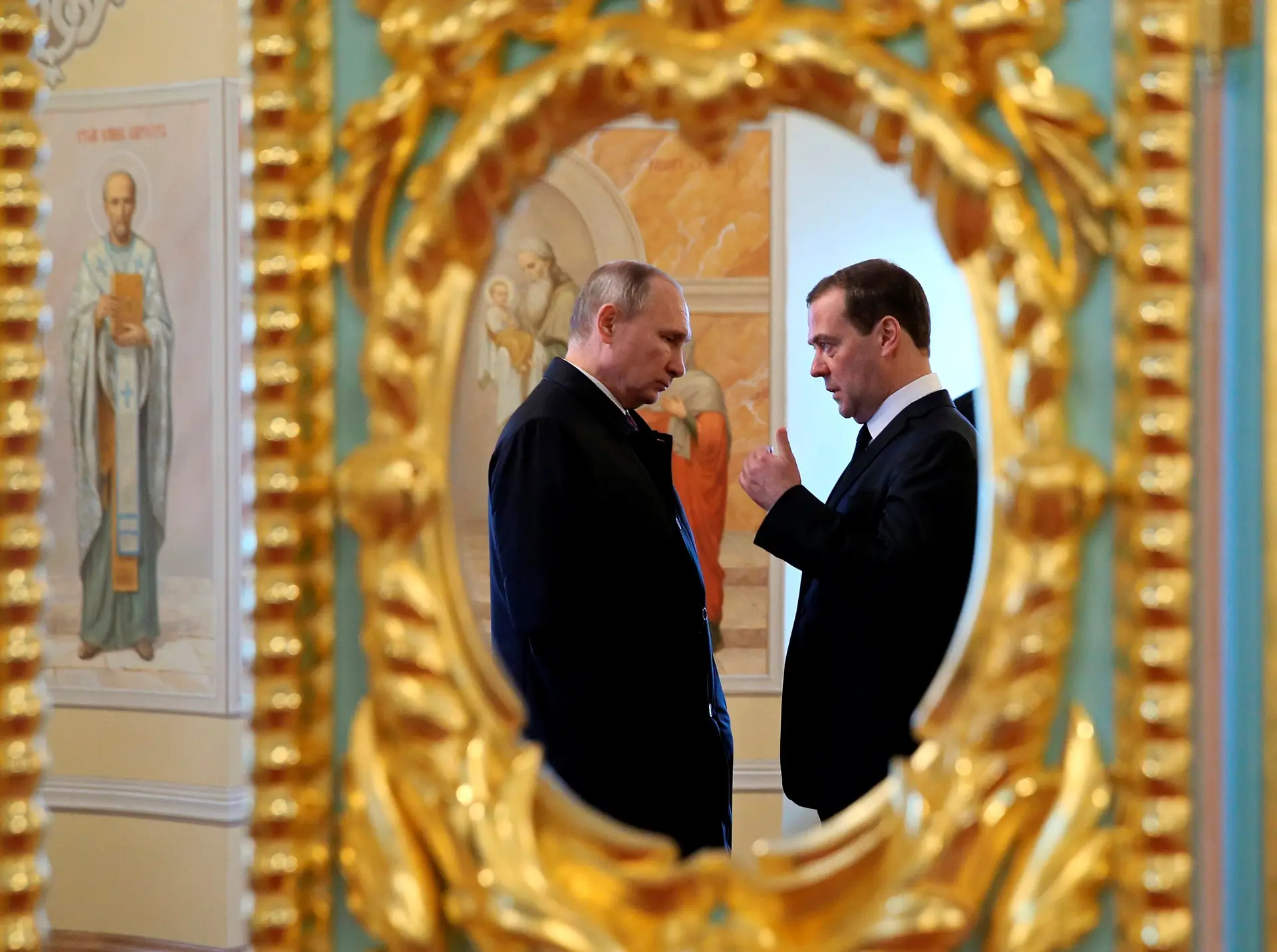 O Presidente Vladimir Putin e o primeiro-ministro Dmitry Medvedev refletidos num espelho, durante uma visita ao Mosteiro de Novojerusalemskiy, em Istra, Rússia.