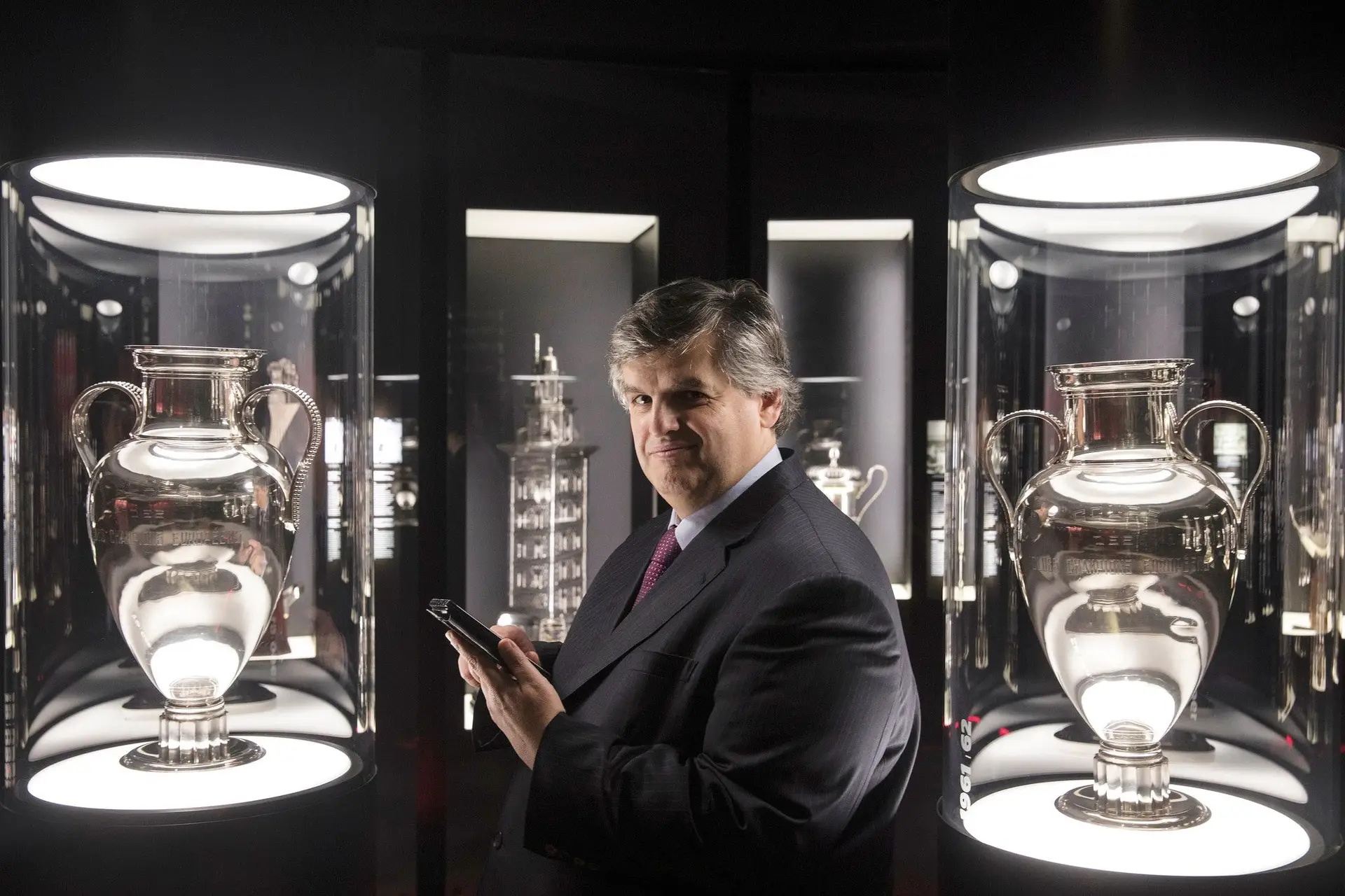 Pedro Guerra fotografado entre as duas Taças dos Clubes Campeões Europeus ganhas pelo Benfica