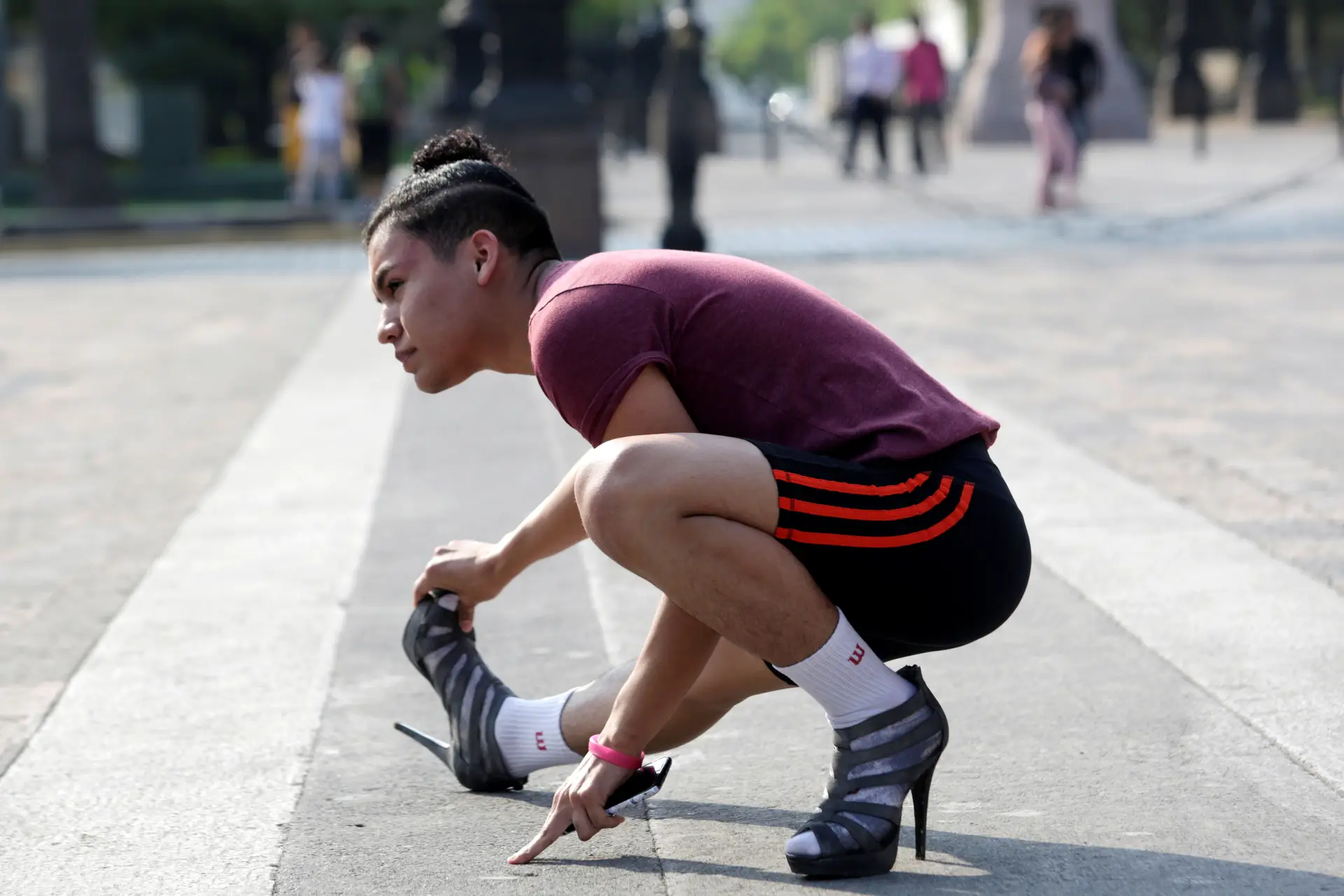 Membro da comunidade LGBT aquece antes de participar numa corrida em saltos altos em Monterrey, México.