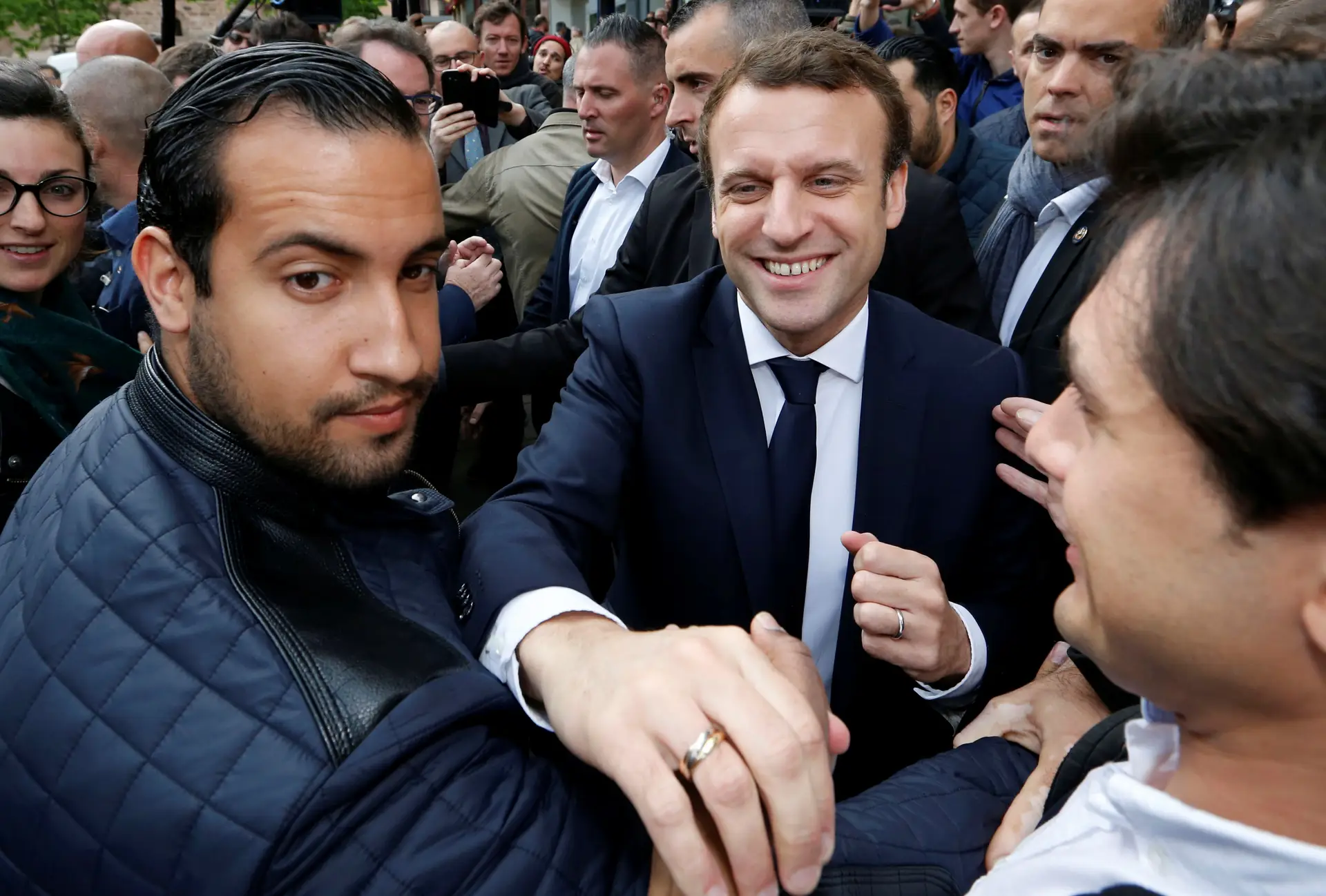 O agente de segurança, Alexandre Benalla (à esquerda na imagem), um dos mais próximos do presidente, foi preso por "violência em grupo por uma pessoa encarregada de uma missão de serviço público, usurpação de funções e posse ilegal de insígnias reservadas à autoridade pública"