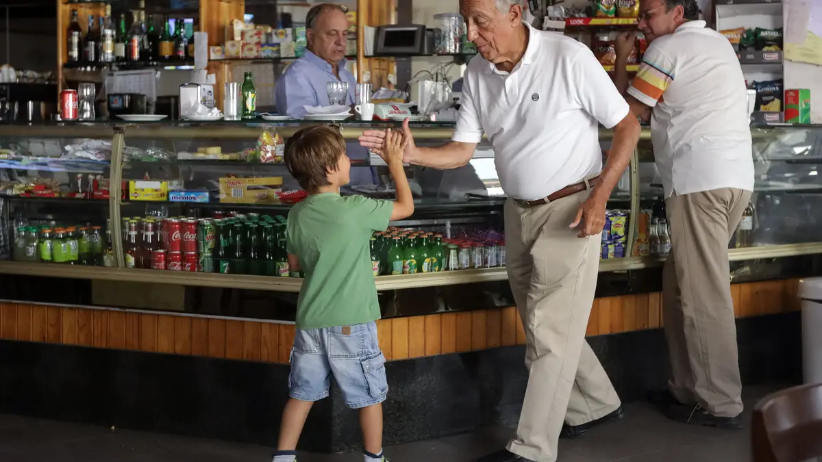 O Presidente da República, Marcelo Rebelo de Sousa, cumprimenta uma criança durante a paragem num café, onde se encontra de férias a percorrer a zona afetada pelos incêndios de 2017, em Pedrógão Grande.