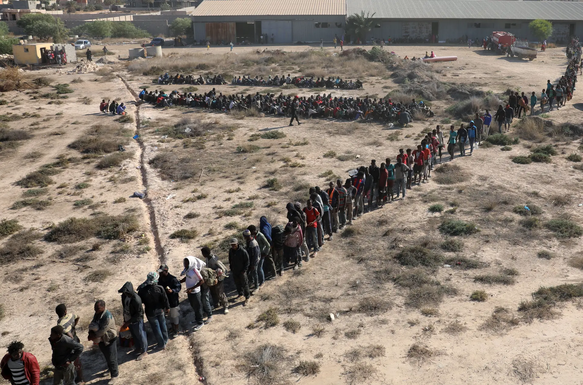 Migrantes detidos aguardam entrada em centros de detenção na Líbia
