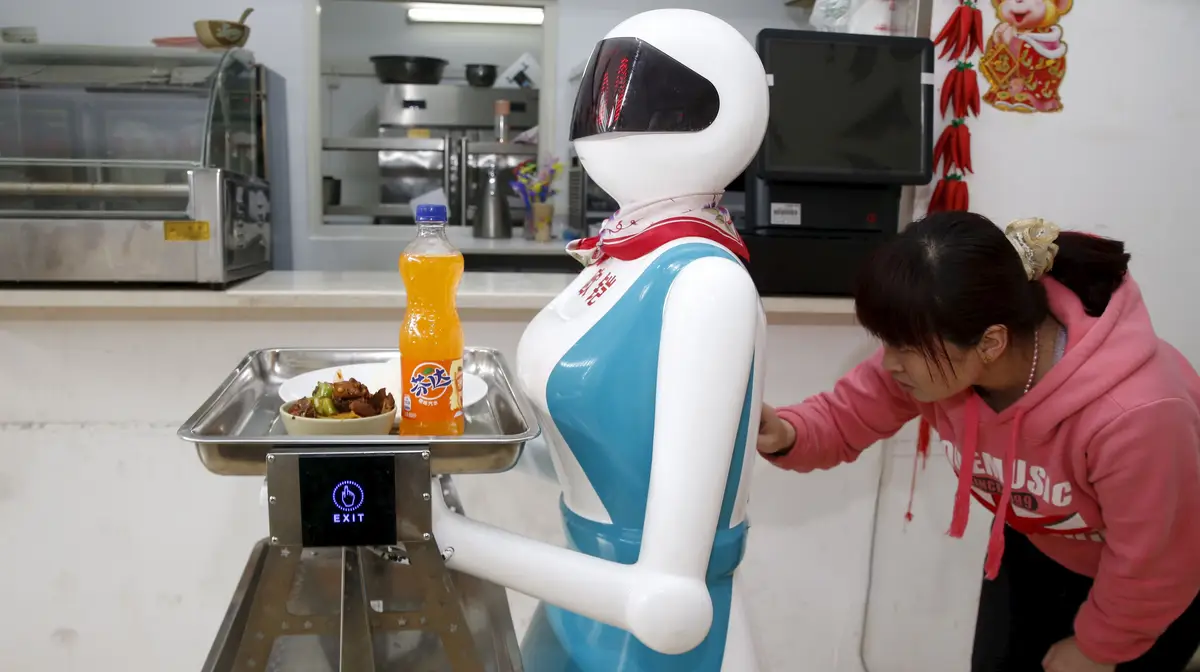 A empregada de mesa de um restaurante de fast food de Shangai, na China onde já há vários restaurantes com tecnologia autónoma a servir às mesas e a ajudar na cozinha