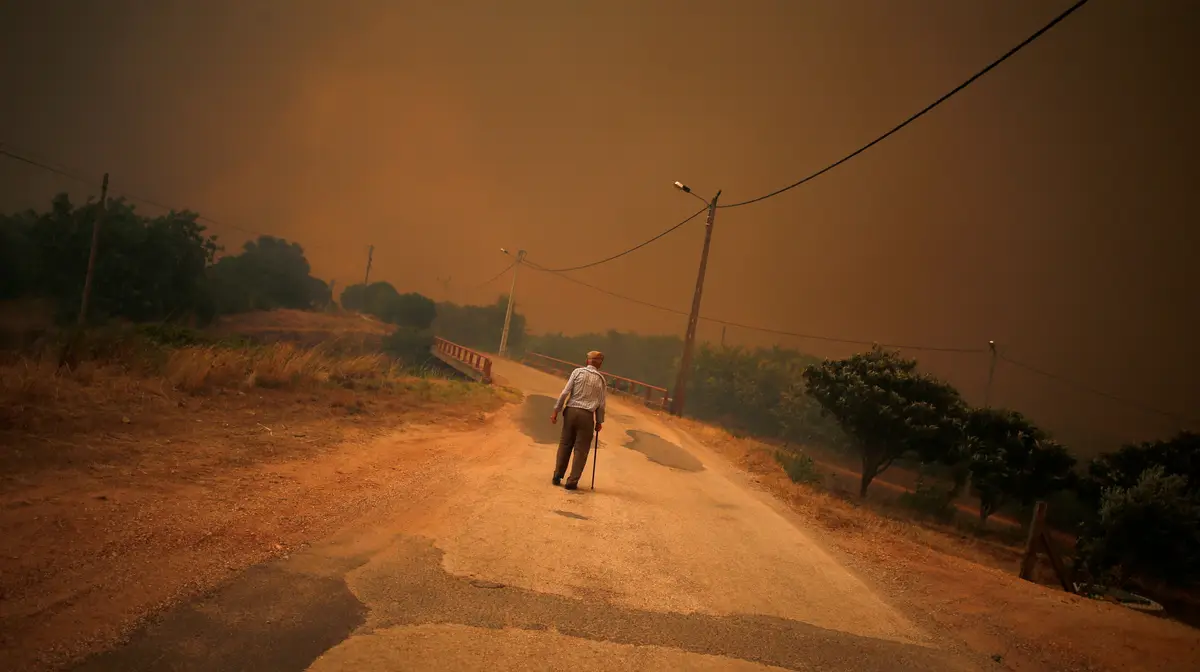 Os incêndios que afetaram o sul de Portugal, no verão. Um homem atravessa uma rua em Pedreira, perto de Silves.