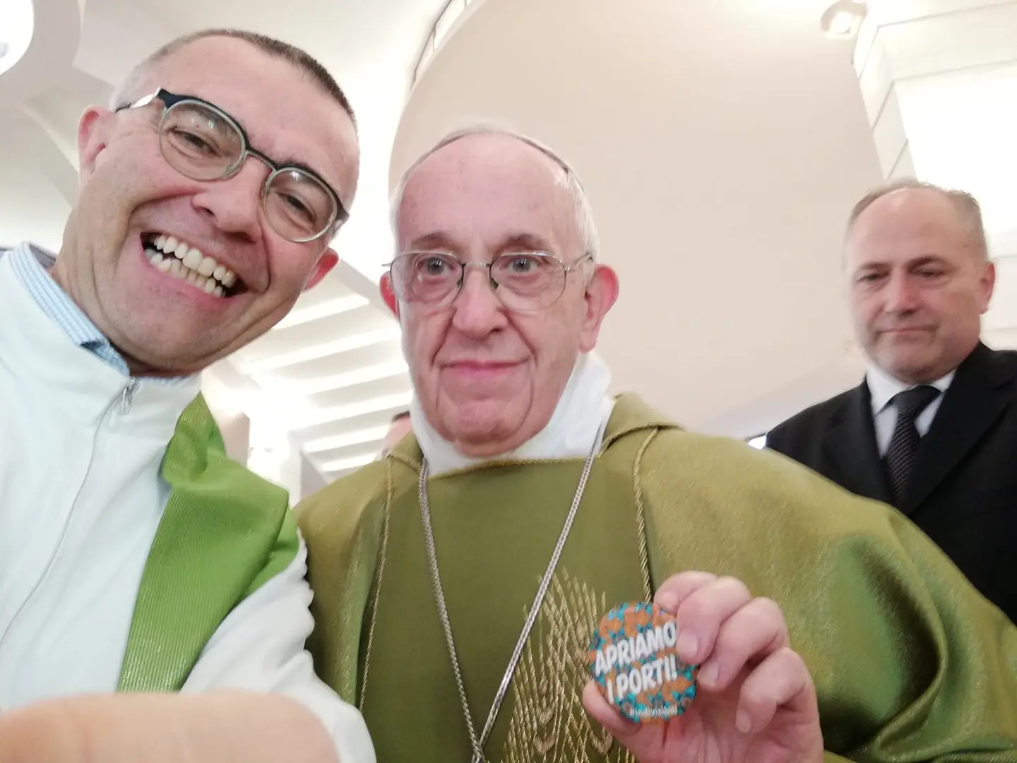 Papa tira fotografia com crachá onde se lê "Vamos abrir os portos"