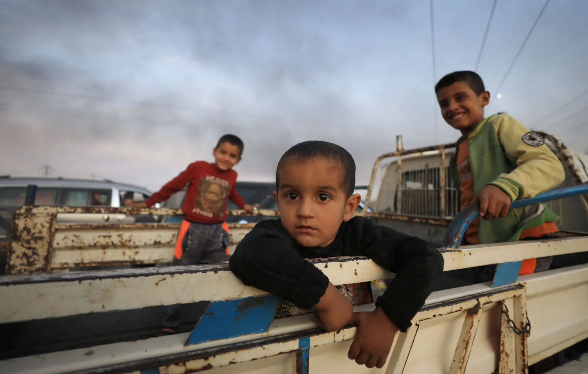 Três crianças tentam fugir da cidade de Ras al Ain, um dos locais mais afetados pela ofensiva turca na fronteira norte da Síria