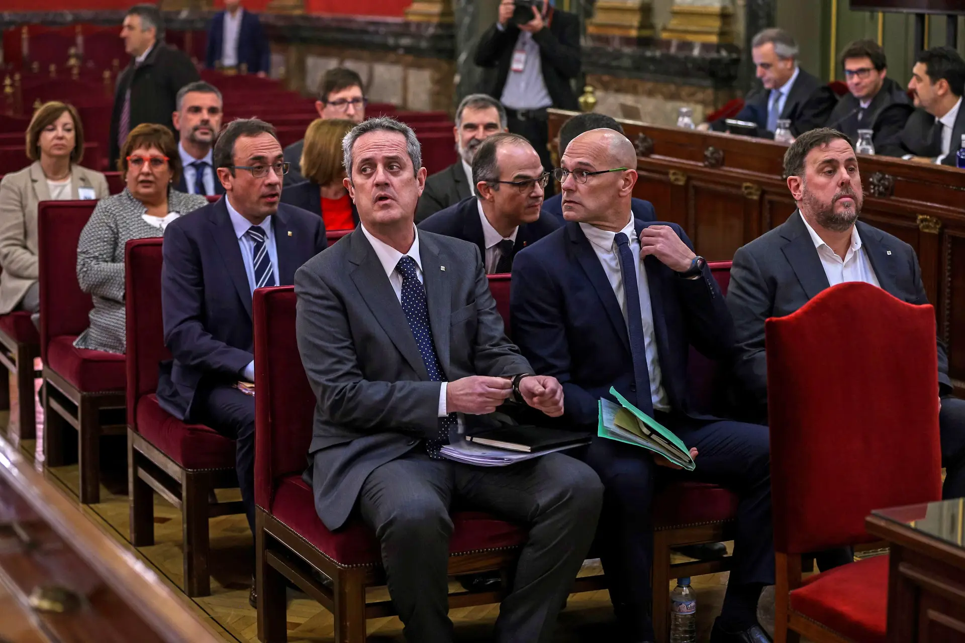 Oriol Junqueras, ex-vice-presidente do governo catalão, à direita, ao centro Raul Romeva, ex-ministro das relações exteriores do governo regional, e Joaquim Forn, à esquerda, antigo responsável regional pela pasta dos assuntos internos. Atrás os restantes nove independentistas catalães, numa foto de 12 de fevereiro de 2012.