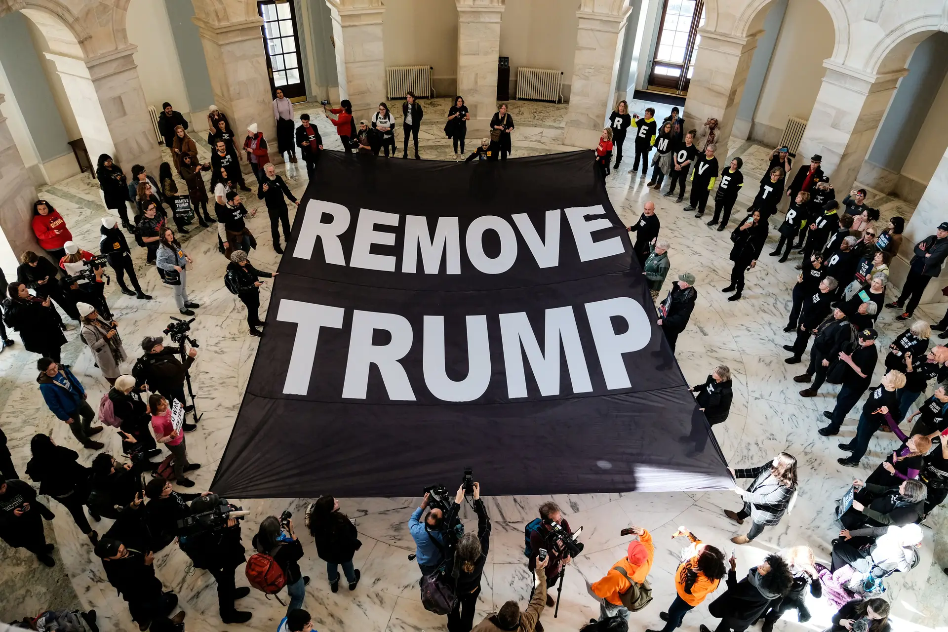 Dezenas de pessoas ocuparam o edifício do Senado, em Washington, e exigiram o afastamento do Presidente norte-americano, enquanto decorriam as cerimónias de juramento dos senadores do processo de impeachment de Donald Trump. O protesto não autorizado durou pouco tempo, a polícia do Capitólio obrigou os manifestantes a abandonarem o local.