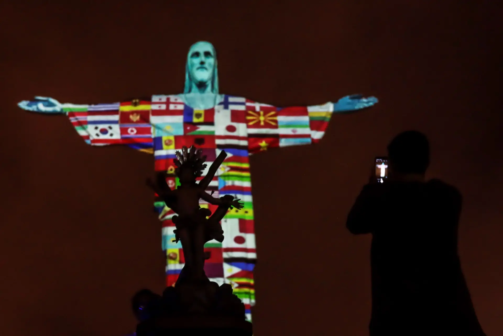 Bandeiras dos países com casos de Covid-19 projetadas no Cristo Redentor no Brasil