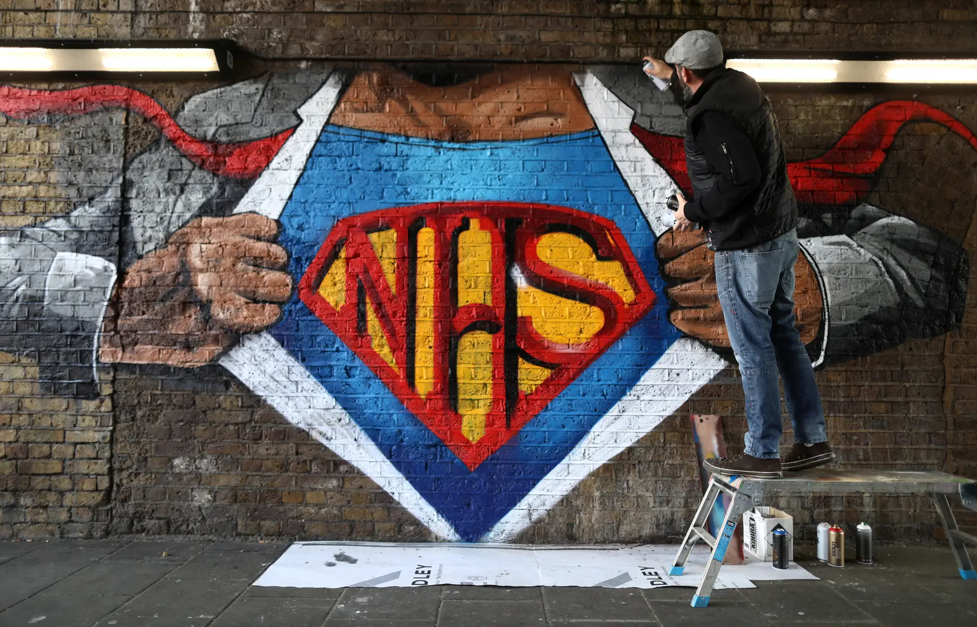 Artista Lionel Stanhope pinta um mural em Londres em homenagem aos profissionais do Serviço Nacional de Saúde britânico, NHS na sigla inglesa.