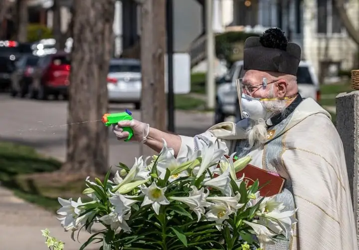 EUA. Padre benze fiéis com pistola de água benta para manter distância social