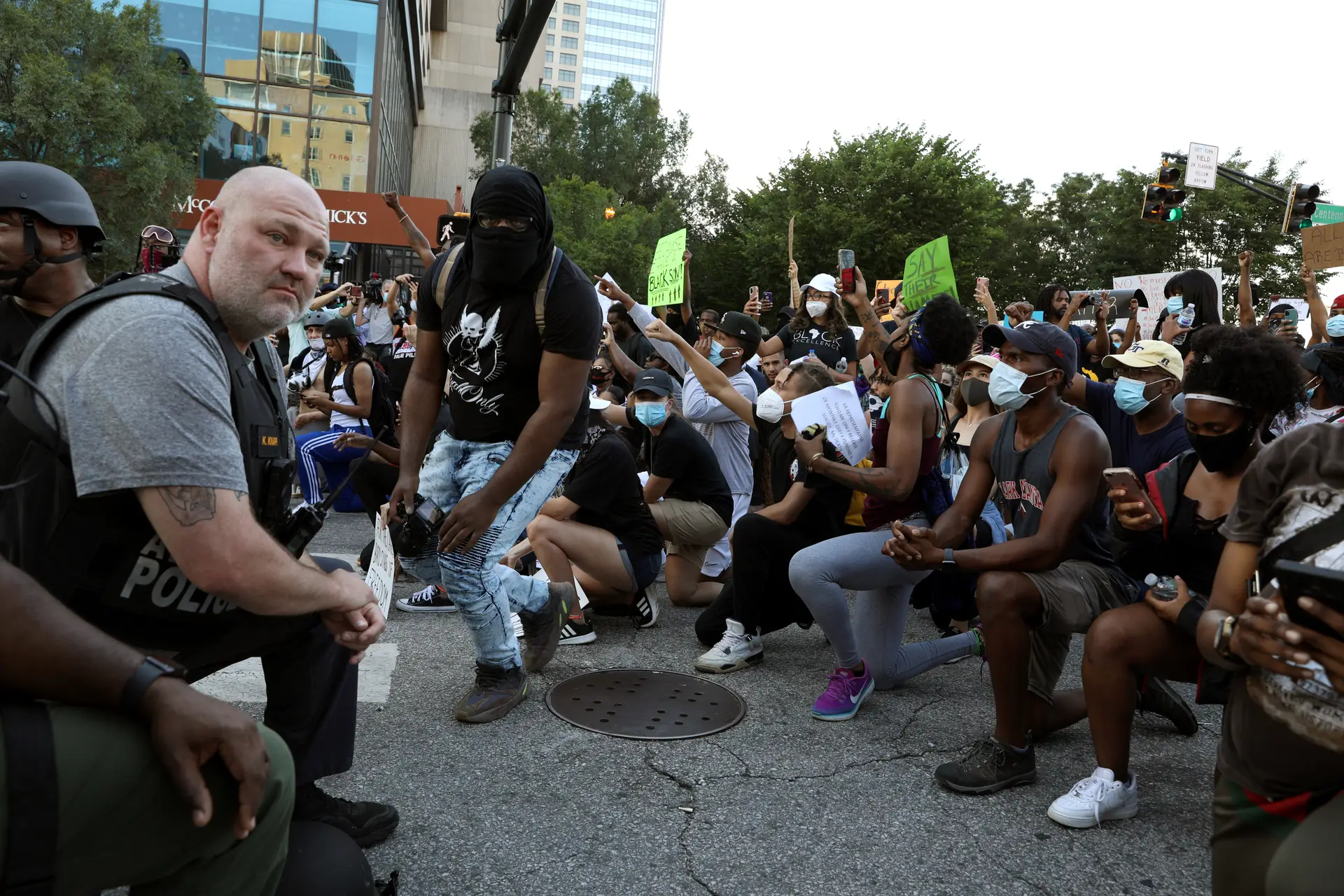 Manifestantes e membros da polícia ajoelham-se durante protestos nos EUA