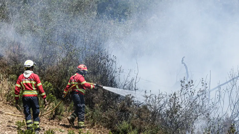Bombeiros durante o combate a um incêndio.