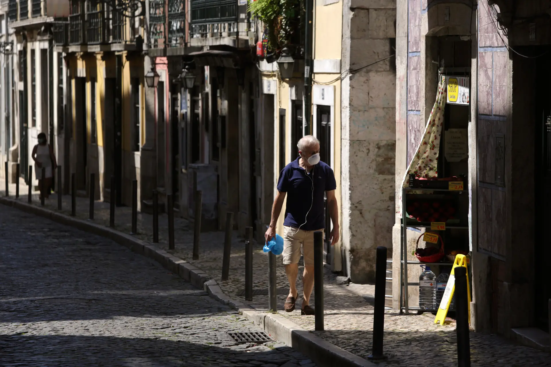 Um homem passeia de máscara numa rua de Lisboa.
