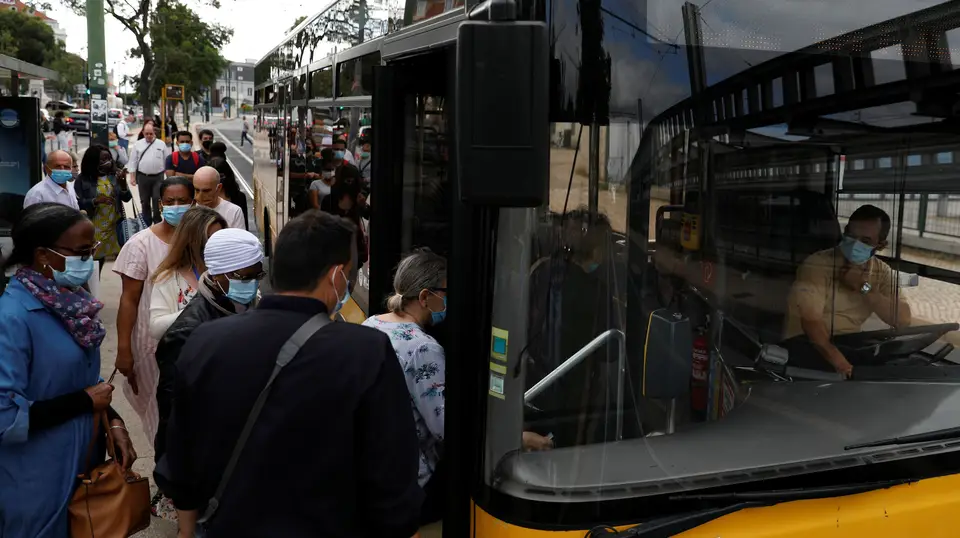 Passageiros tentam manter a distância social à entrada do autocarro em Lisboa.