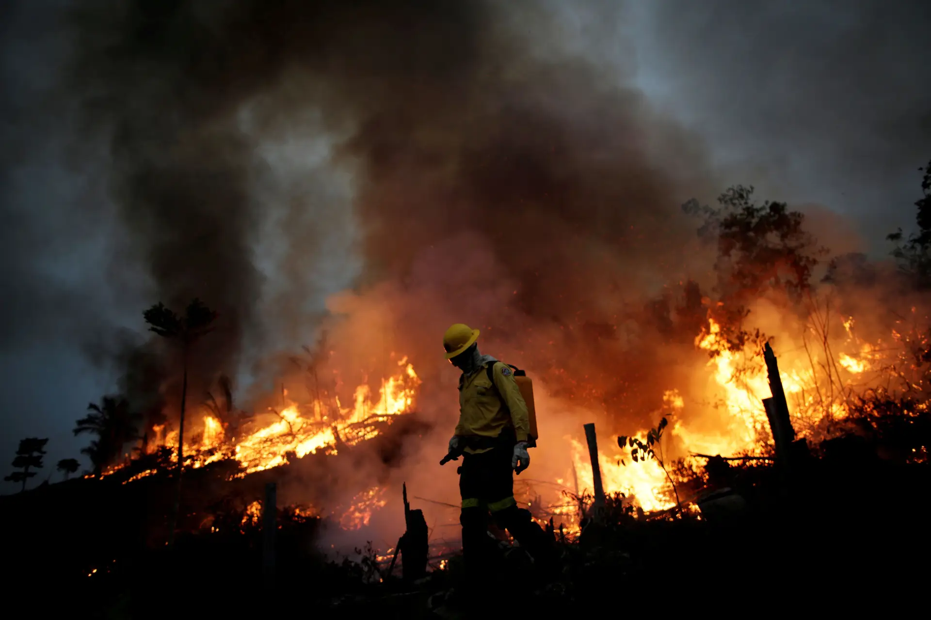 Um bombeiro do Instituto Brasileiro do Meio Ambiente e dos Recursos Naturais Renováveis combate as chamas na zona de Apuí, na floresta da Amazónia.