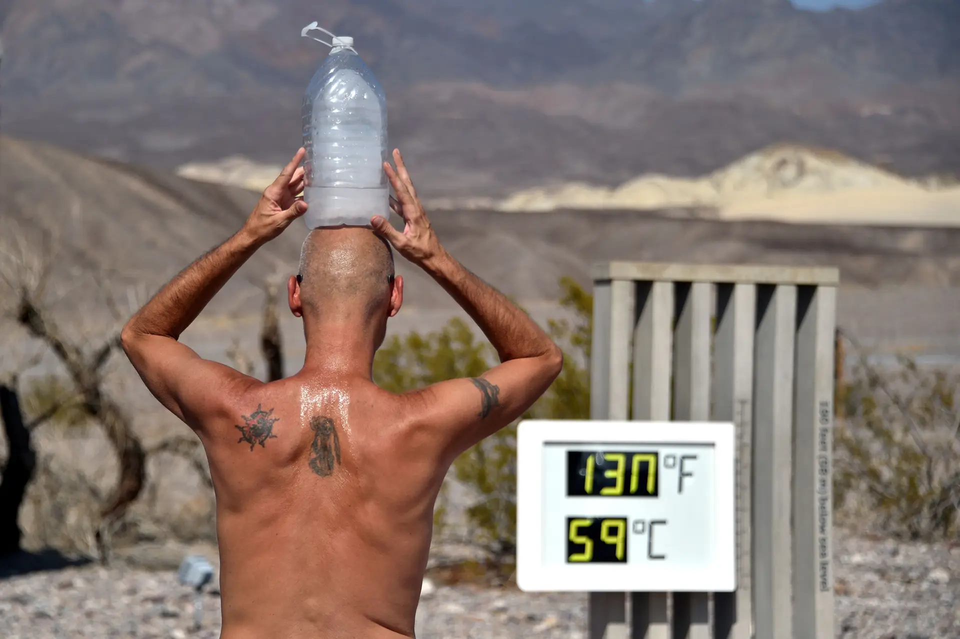 Um norte-americano tenta refrescar-se à frente de um termómetro, na Vale da Morte, Califórnia.