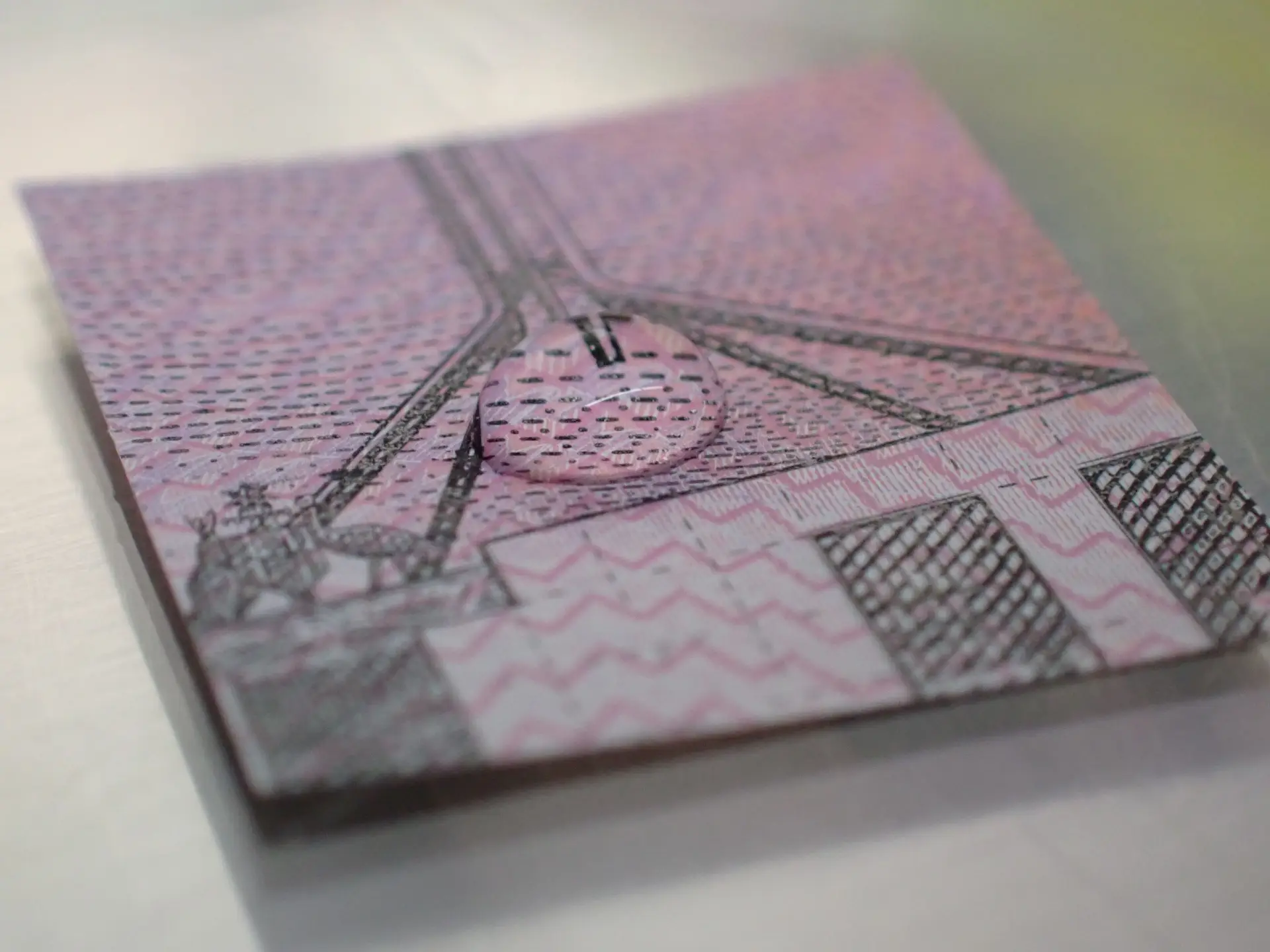 Gotícula de SARS-CoV-2 em muco artificial num pedaço de nota de cinco dólares australiana.