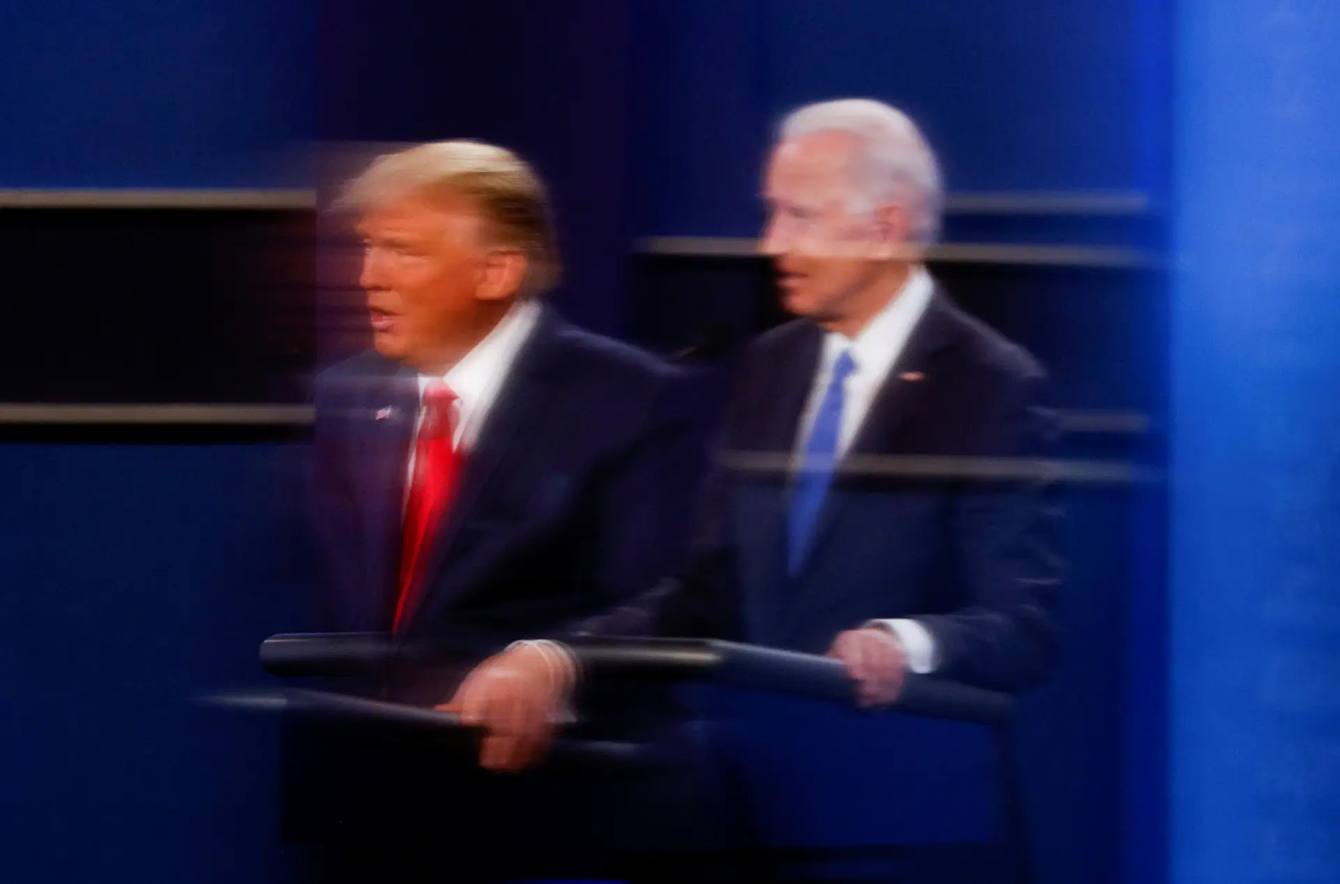 O Presidente dos Estados Unidos, Donald Trump, e o candidato democrata Joe Biden refletidos num separador de acrílico durante o debate presidencial.